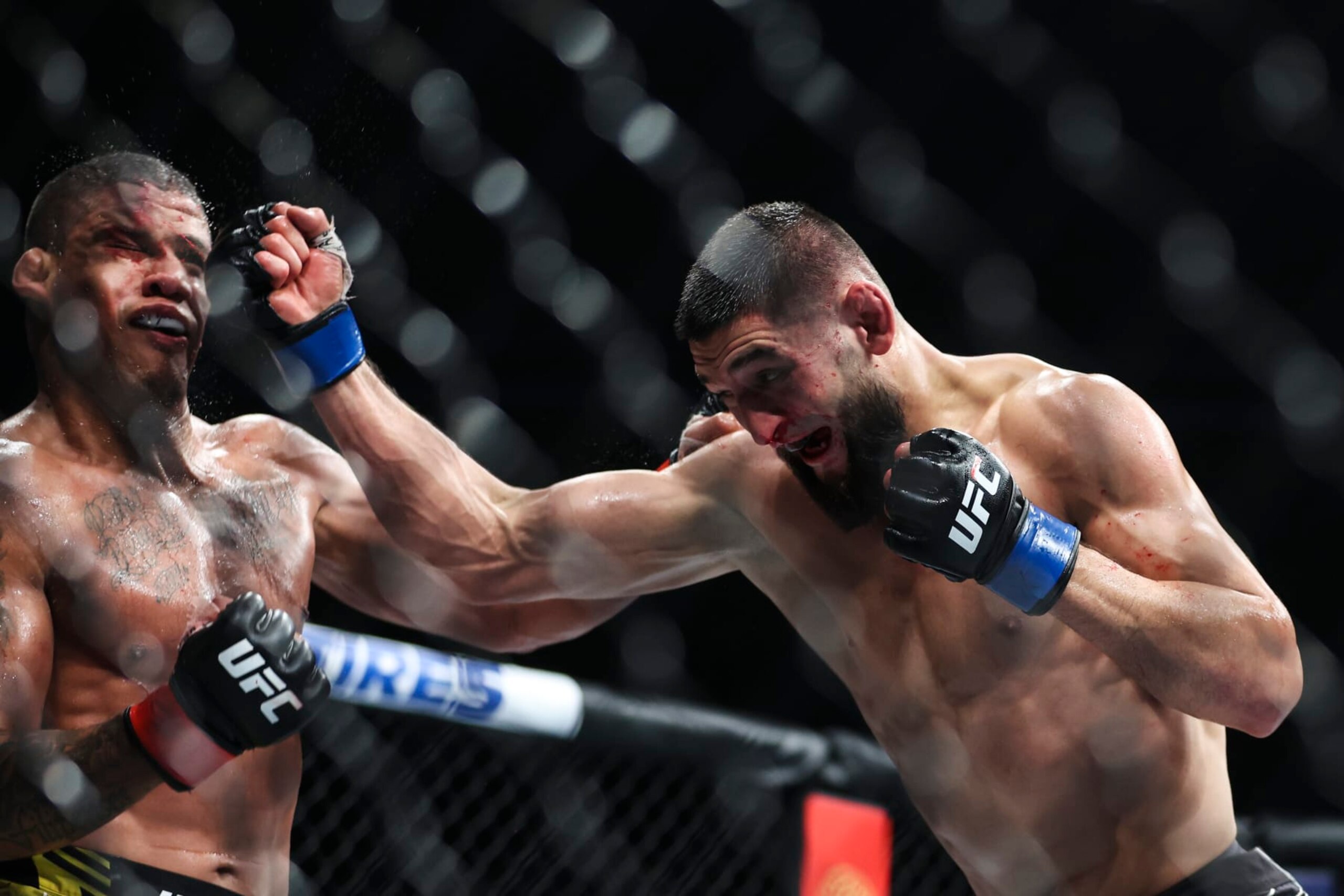JACKSONVILLE, FLORIDA - APRIL 09: Khamzat Chimaev of Russia punches Gilbert Burns of Brazil in their welterweight fight during the UFC 273 event at VyStar Veterans Memorial Arena on April 09, 2022 in Jacksonville, Florida. (Photo by James Gilbert/Getty Images)