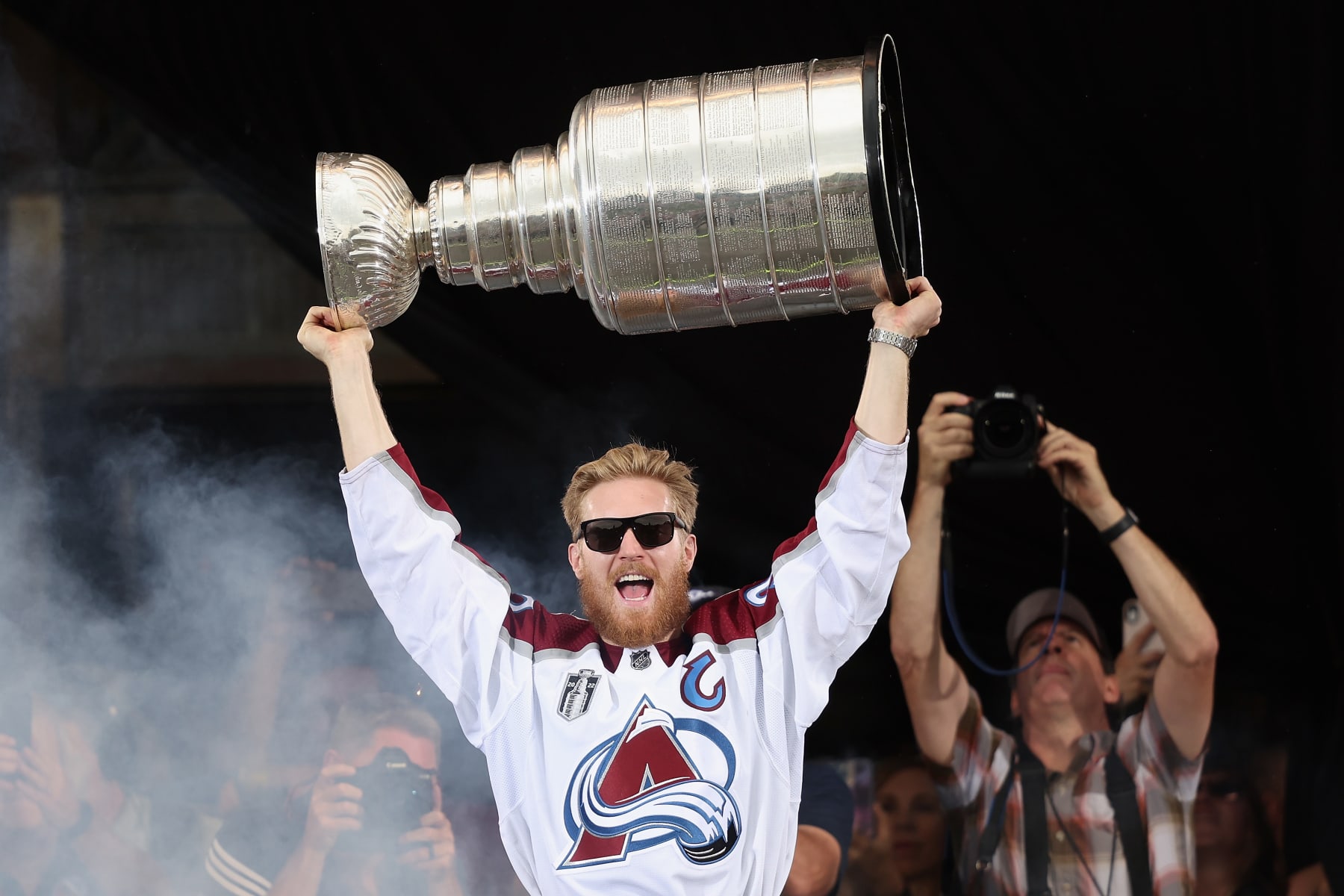 DENVER, COLORADO - JUNE 30: Gabriel Landeskog #92 of the Colorado Avalanche lifts the Stanley Cup on-stage during the Colorado Avalanche Victory Parade and Rally at Civic Center Park on June 30, 2022 in Denver, Colorado. (Photo by Matthew Stockman/Getty Images)
