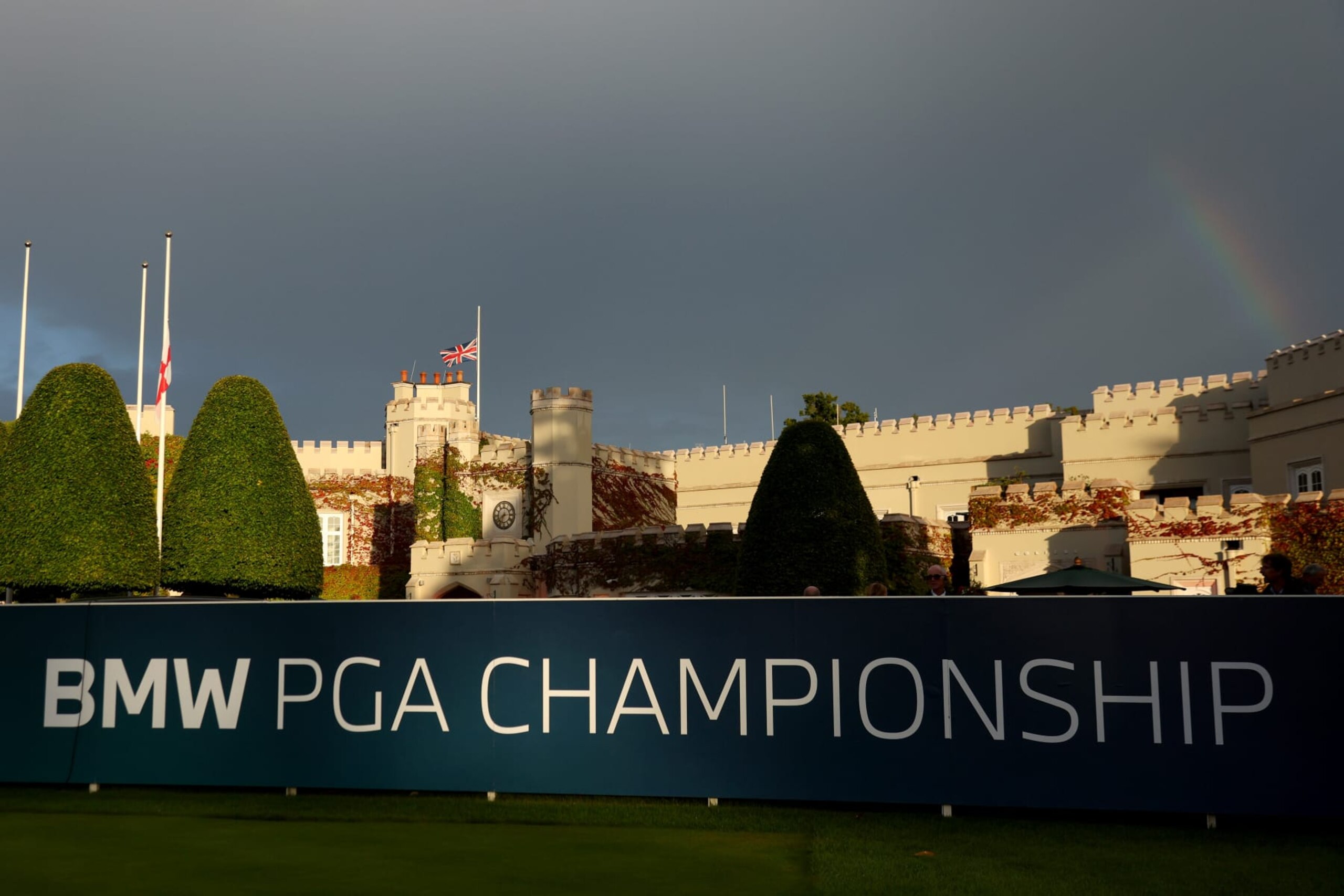 VIRGINIA WATER, ENGLAND - SEPTEMBER 08: A rainbow is seen as flags are flown at half-mast at the 1st tee following the announcement of the death of Her Majesty Queen Elizabeth II during Day One of the BMW PGA Championship at Wentworth Golf Club on September 08, 2022 in Virginia Water, England. (Photo by Andrew Redington/Getty Images)