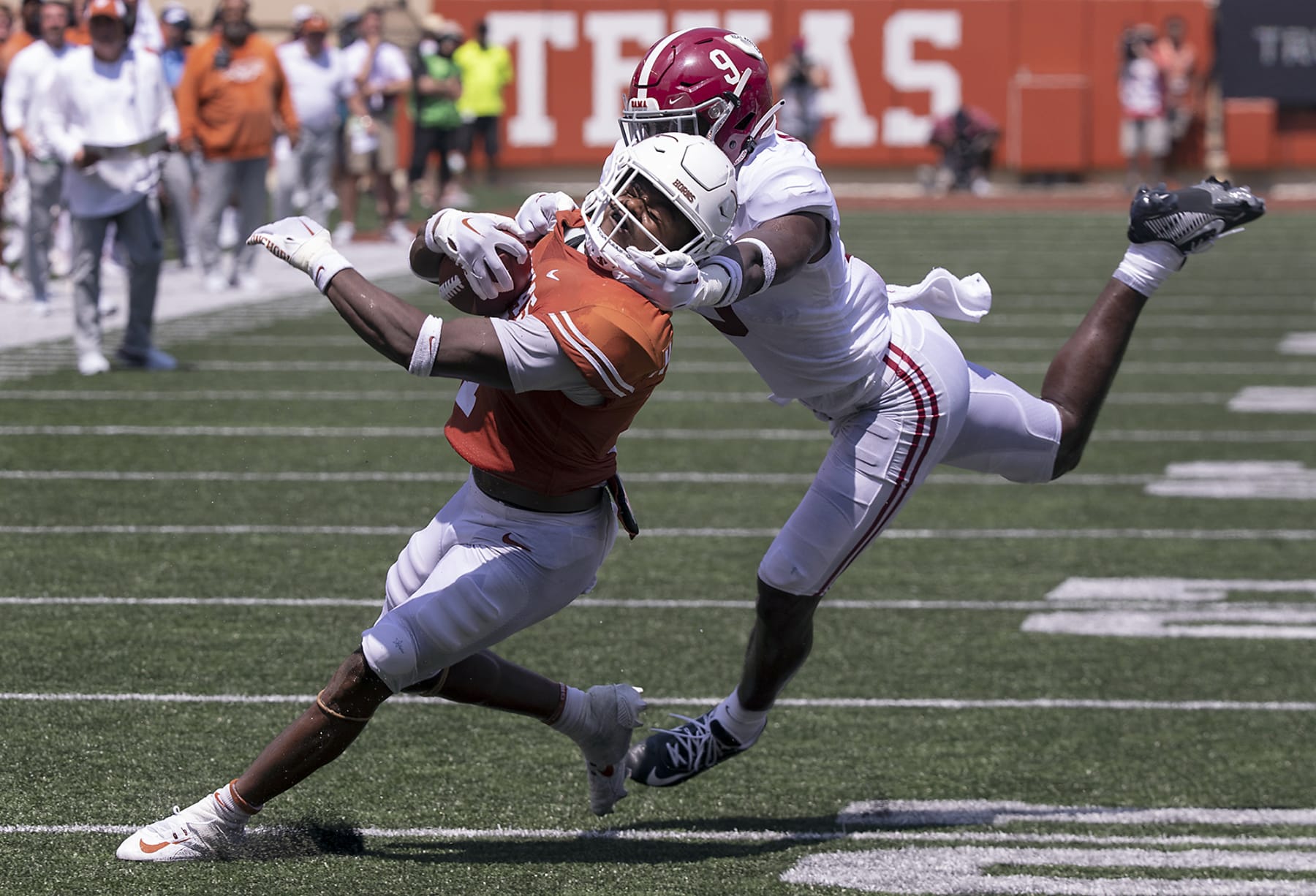 Texas running back Keilan Robinson (7) has his face mask grabbed by Alabama defensive back Jordan Battle (9) during the second half of an NCAA college football game, Saturday, Sept. 10, 2022, in Austin, Texas. Alabama defeated Texas 20-19. (AP Photo/Rodolfo Gonzalez)