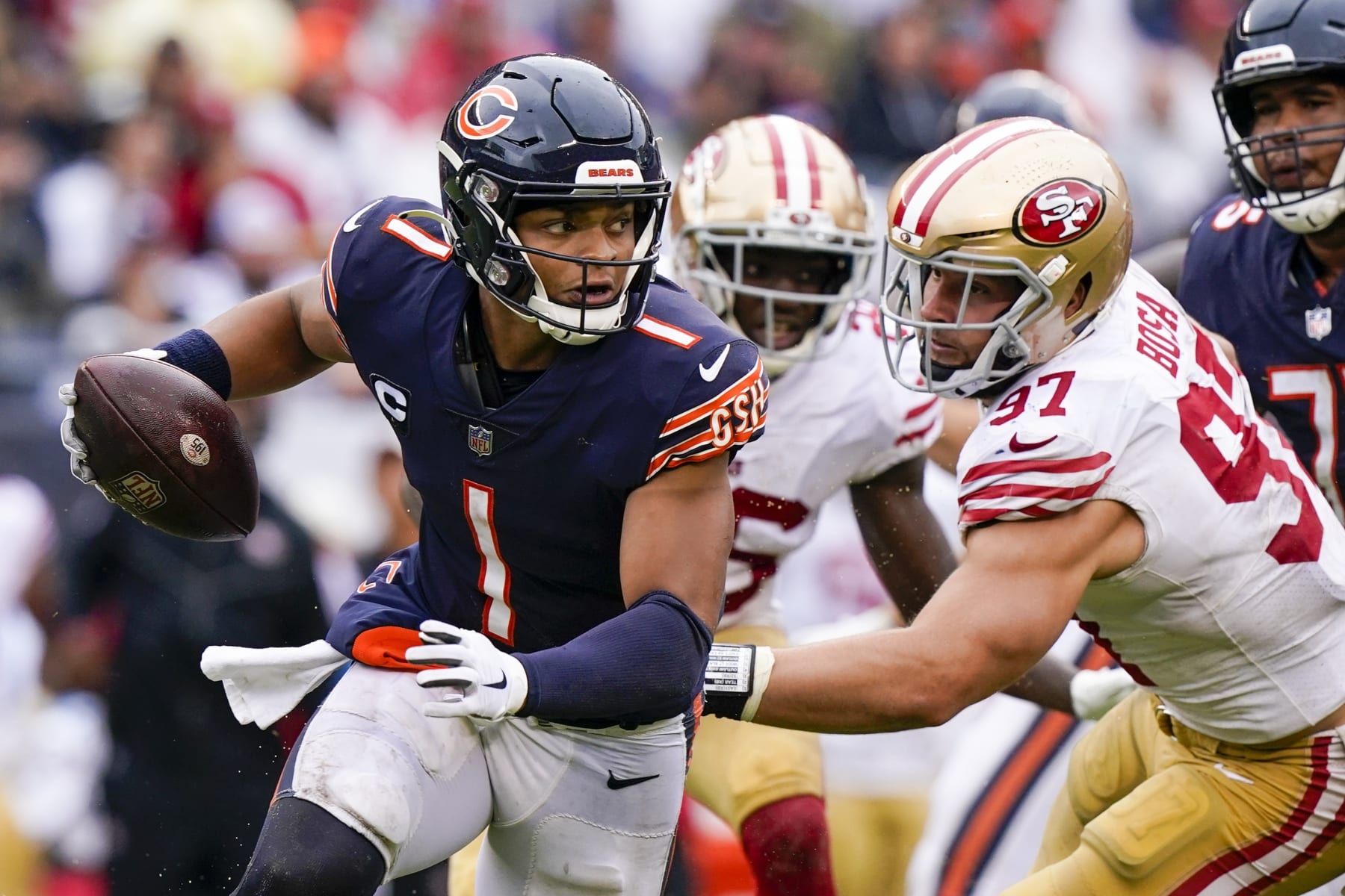 Chicago Bears' Justin Fields scrambles past San Francisco 49ers' Nick Bosa during the second half of an NFL football game Sunday, Sept. 11, 2022, in Chicago. (AP Photo/Nam Y. Huh)