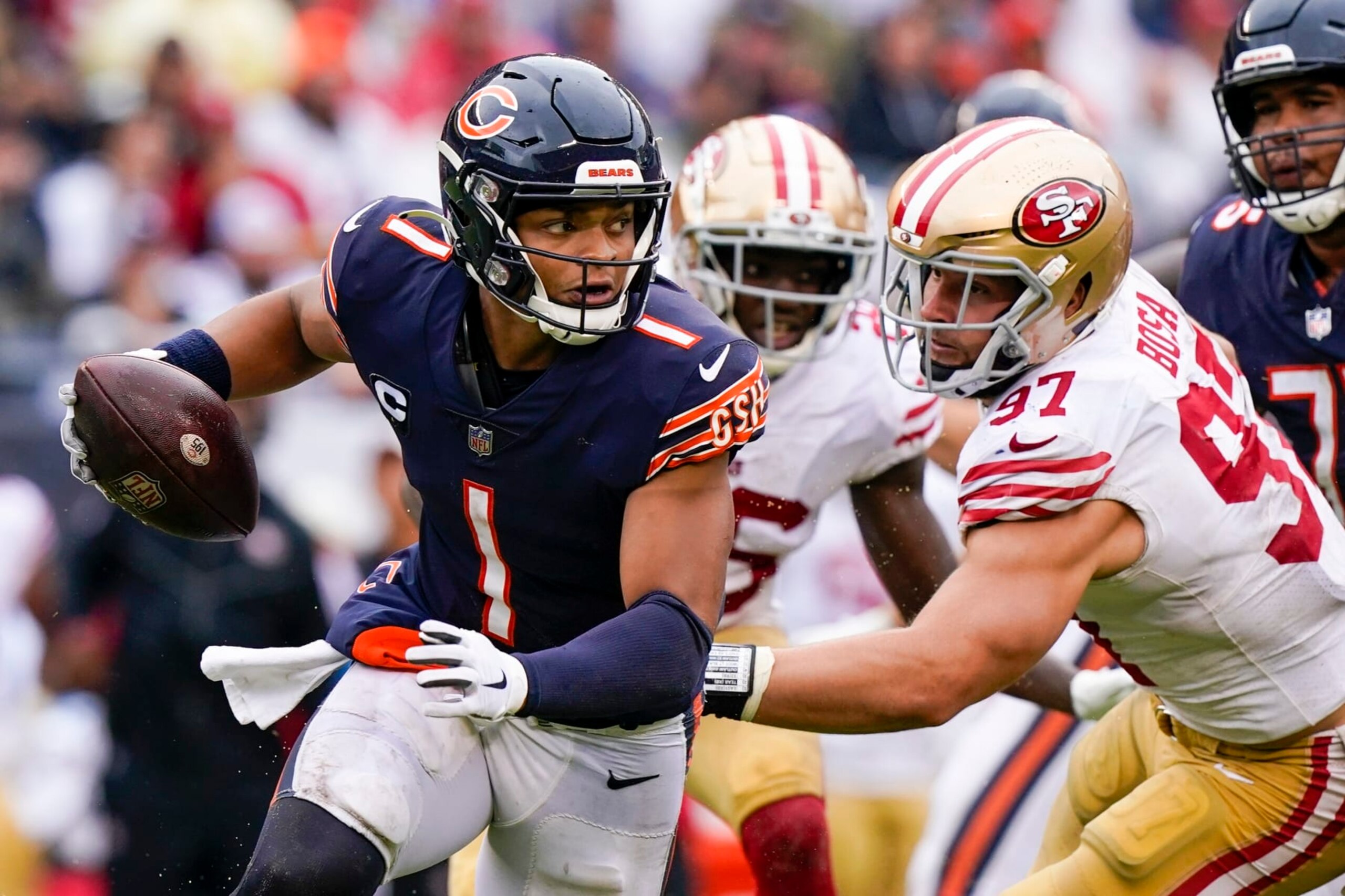 Chicago Bears' Justin Fields scrambles past San Francisco 49ers' Nick Bosa during the second half of an NFL football game Sunday, Sept. 11, 2022, in Chicago. (AP Photo/Nam Y. Huh)