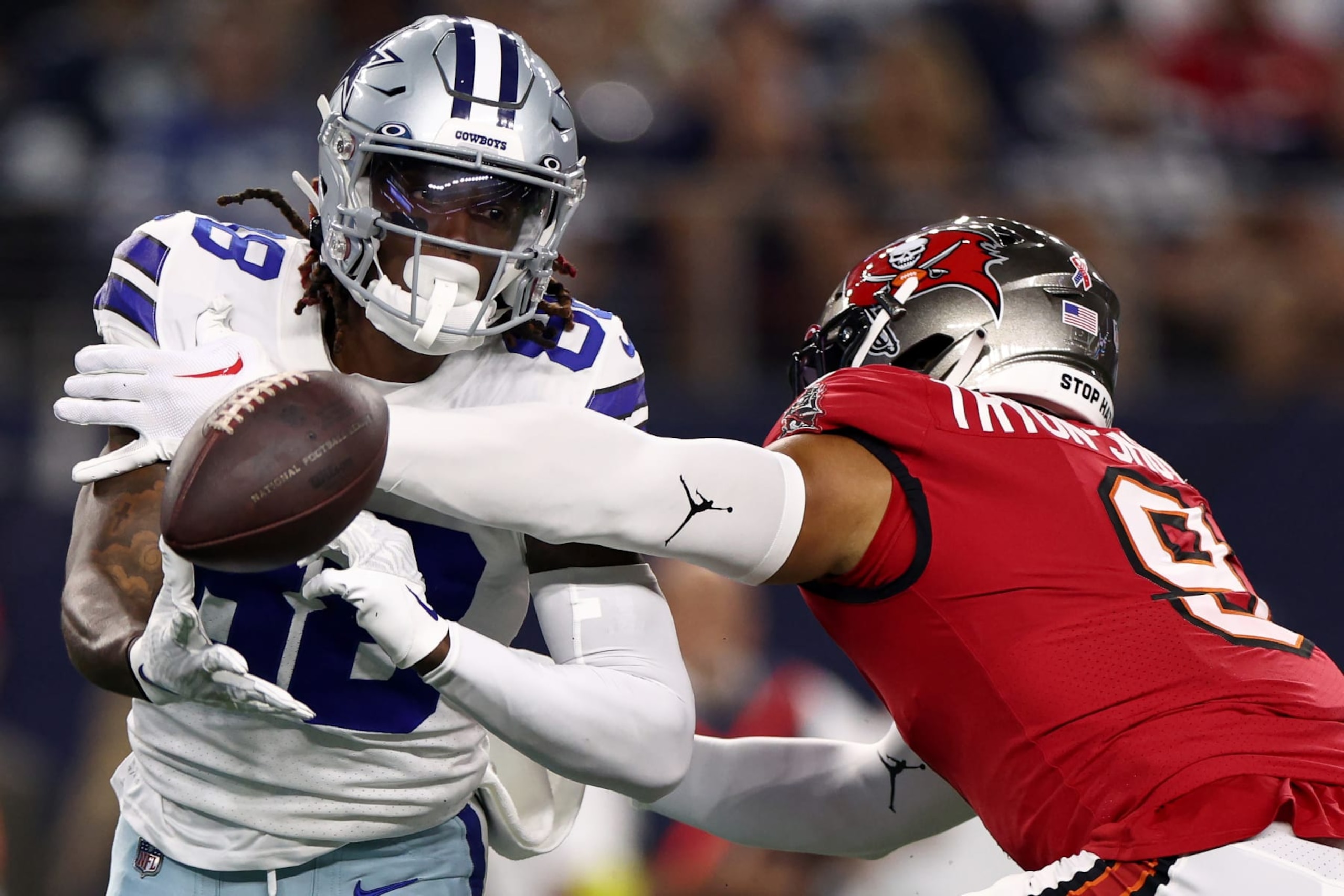 ARLINGTON, TEXAS - SEPTEMBER 11: CeeDee Lamb #88 of the Dallas Cowboys pitches the ball off past Joe Tryon-Shoyinka #9 of the Tampa Bay Buccaneers during the first quarter at AT&T Stadium on September 11, 2022 in Arlington, Texas. (Photo by Tom Pennington/Getty Images)
