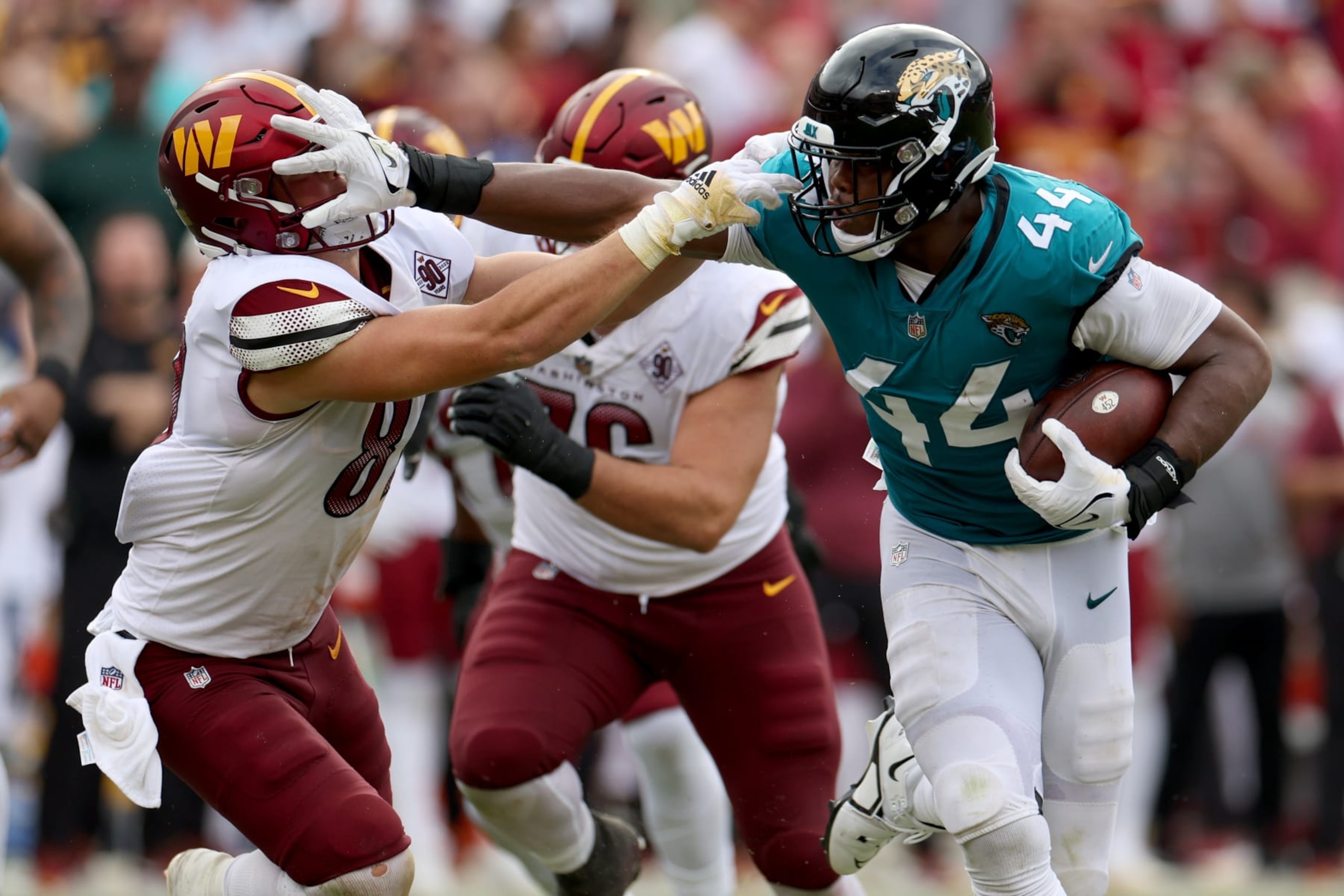 LANDOVER, MARYLAND - SEPTEMBER 11: Travon Walker #44 of the Jacksonville Jaguars stiff arms John Bates #87 of the Washington Commanders after intercepting a pass during the fourth quarter at FedExField on September 11, 2022 in Landover, Maryland. (Photo by Rob Carr/Getty Images)