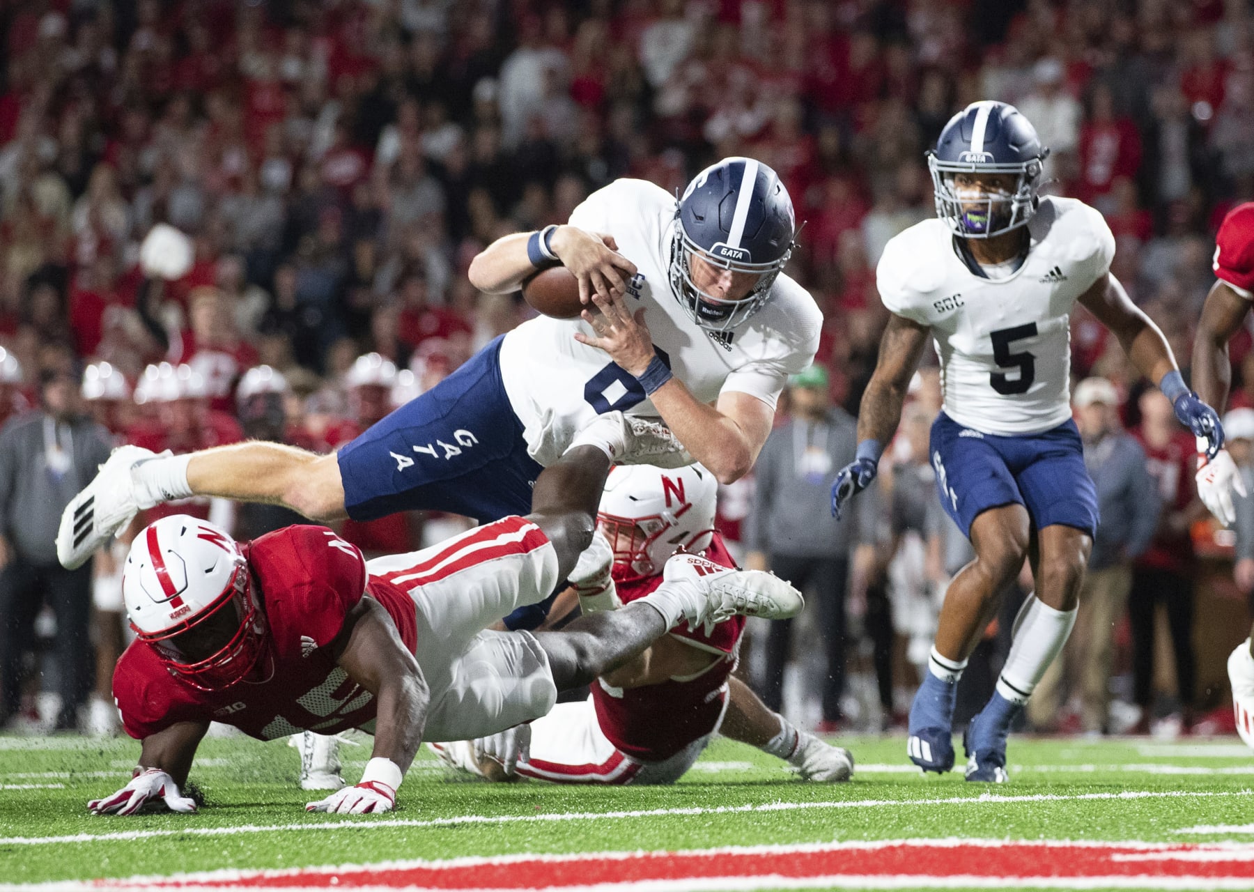 Georgia Southern quarterback Kyle Vantrease (6) leaps over Nebraska's Ernest Hausmann (15) to score a touchdown during the second half of an NCAA college football game Saturday, Sept. 10, 2022, in Lincoln, Neb. Georgia Southern won 45-42. (AP Photo/Rebecca S. Gratz)