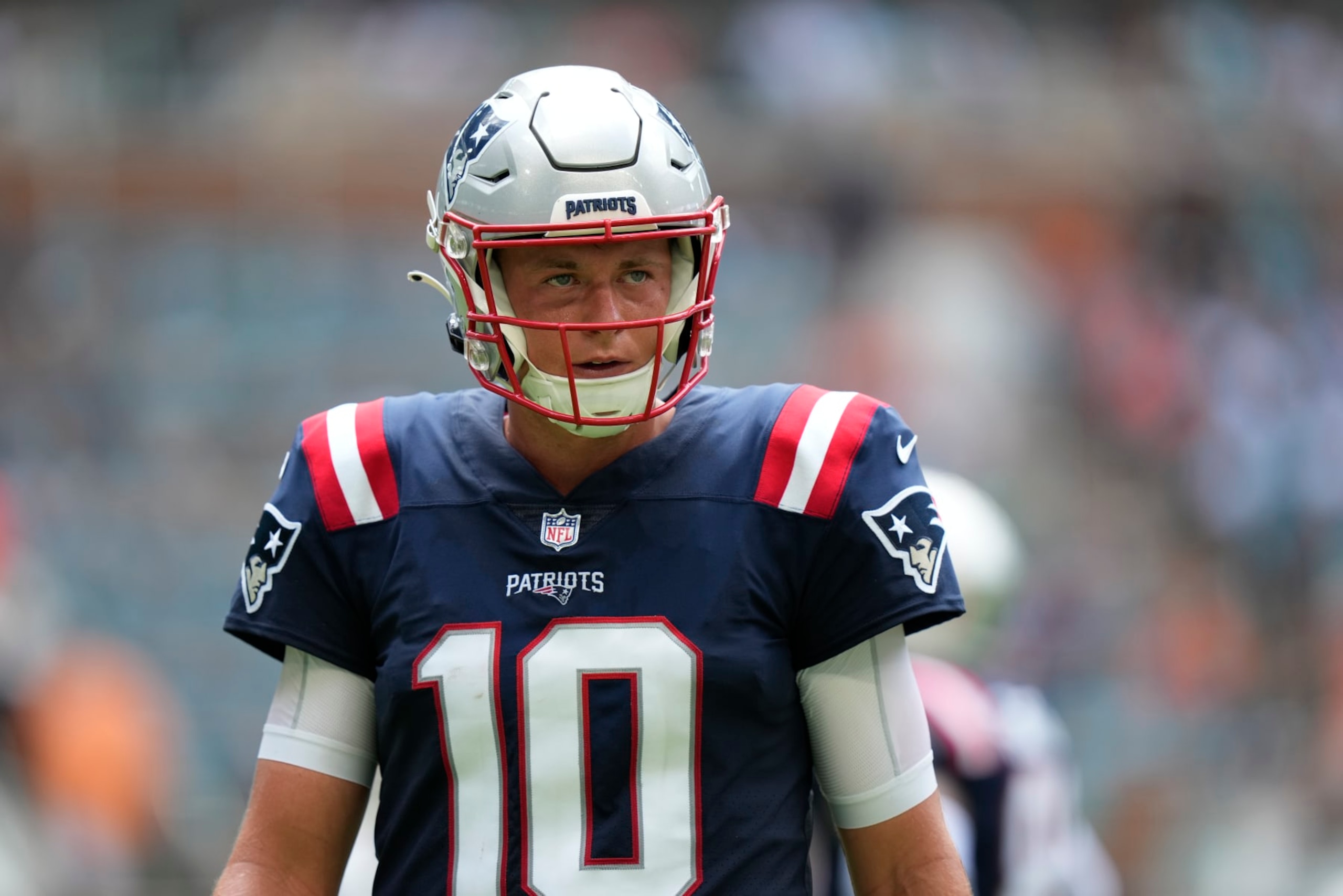 MIAMI GARDENS, FL - September 11: New England Patriots quarterback Mac Jones (10) looks at a coach in between plays during the game between the New England Patriots  and the Miami Dolphins, on Sunday, September 11, 2022 at Hard Rock Stadium in Miami Gardens, FL (Photo by Peter Joneleit/Icon Sportswire via Getty Images)