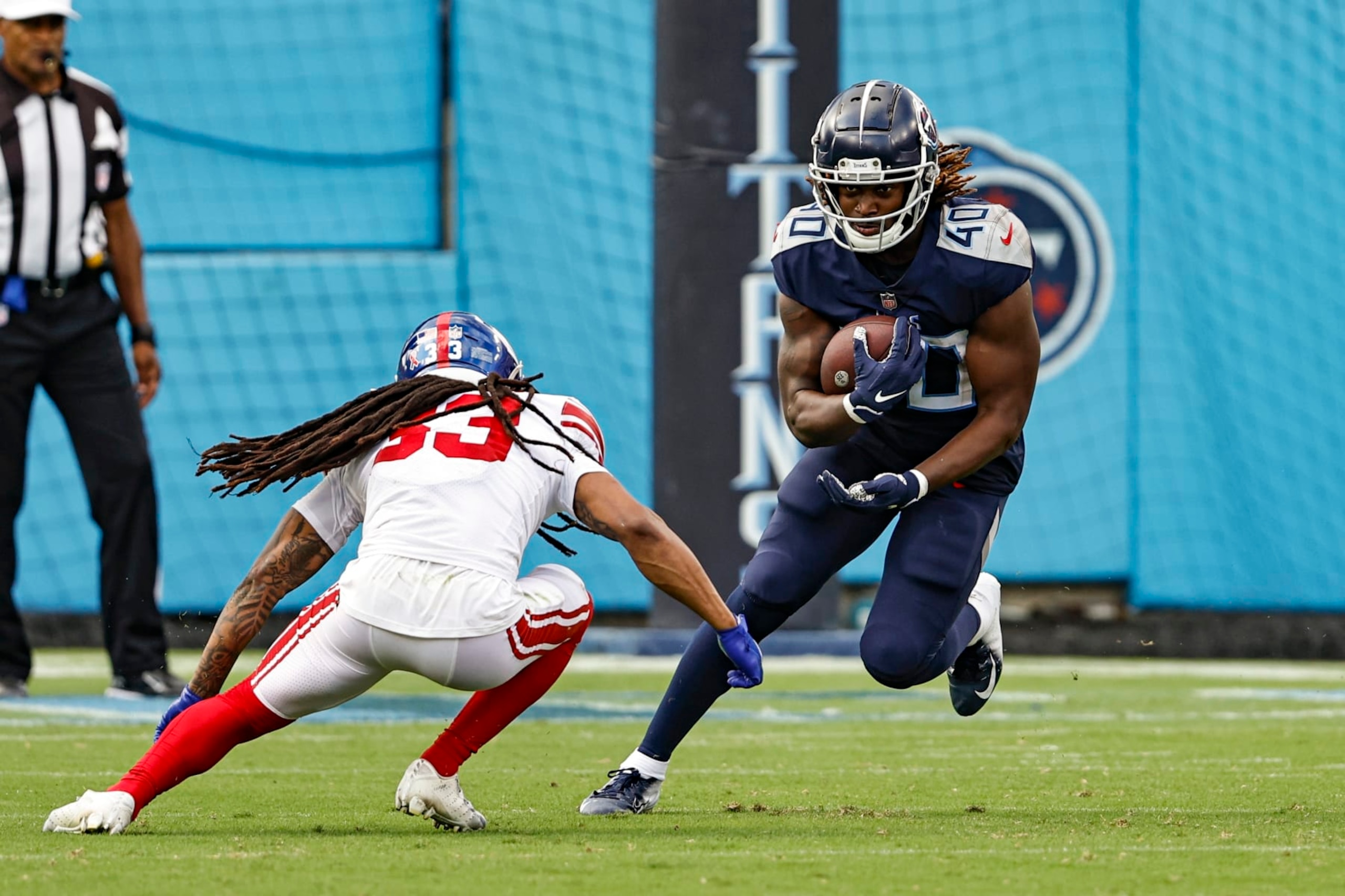 Tennessee Titans running back Dontrell Hilliard (40) runs for yardage as he tries avoid being tackled by New York Giants linebacker Oshane Ximines (53) during their game Sunday, Sept. 11, 2022, in Nashville, Tenn. (AP Photo/Wade Payne)