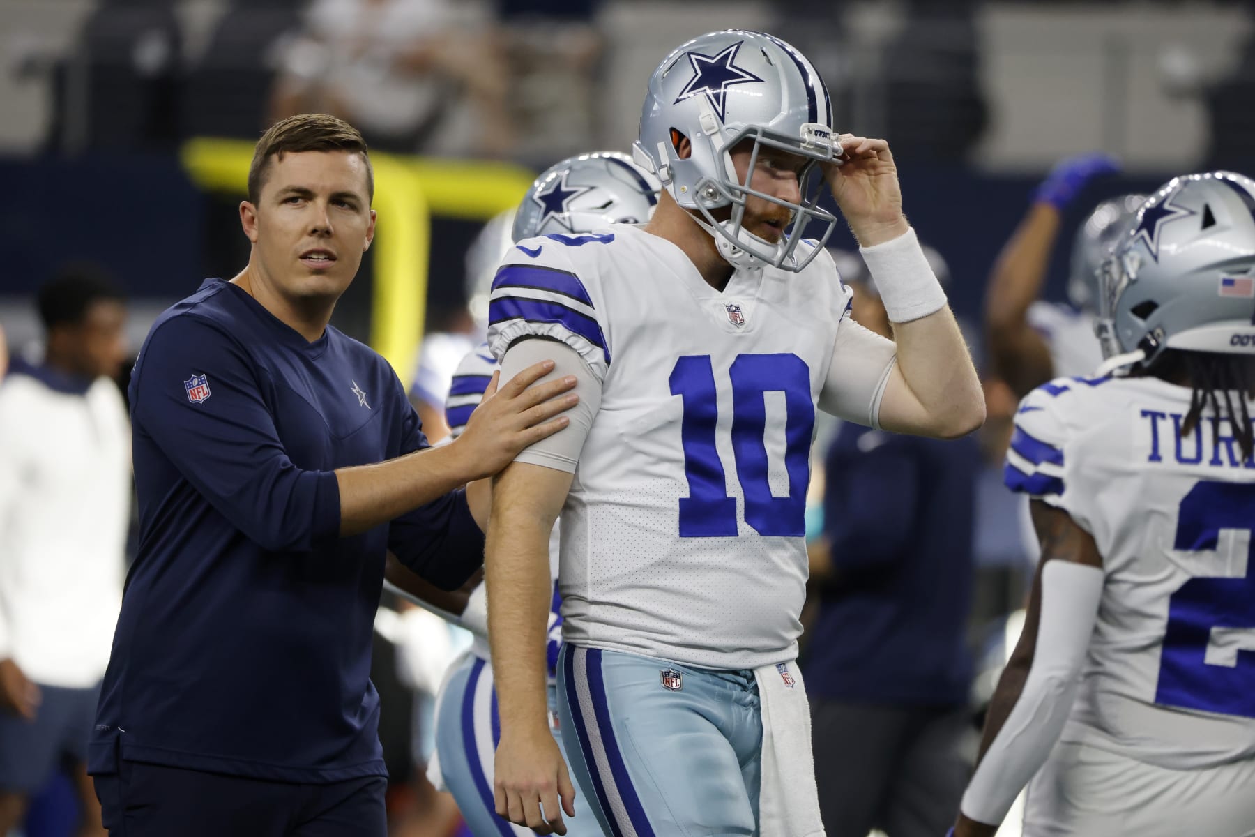 Dallas Cowboys offensive coordinator Kellen Moore talks with quarterback Cooper Rush (10) during warmups before a preseason NFL football game against the Seattle Seahawks in Arlington, Texas, Friday, Aug. 26, 2022. (AP Photo/Michael Ainsworth)