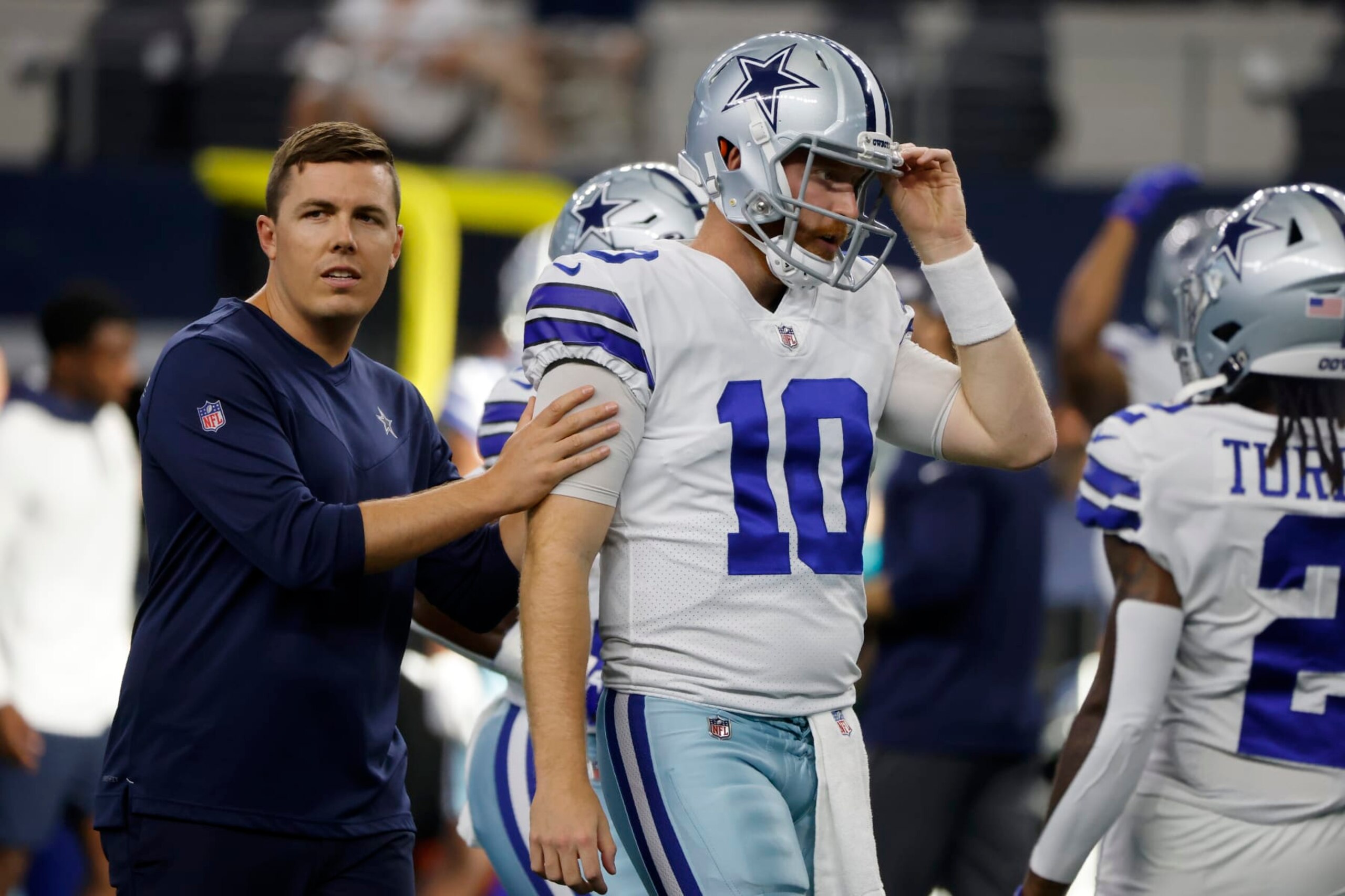 Dallas Cowboys offensive coordinator Kellen Moore talks with quarterback Cooper Rush (10) during warmups before a preseason NFL football game against the Seattle Seahawks in Arlington, Texas, Friday, Aug. 26, 2022. (AP Photo/Michael Ainsworth)