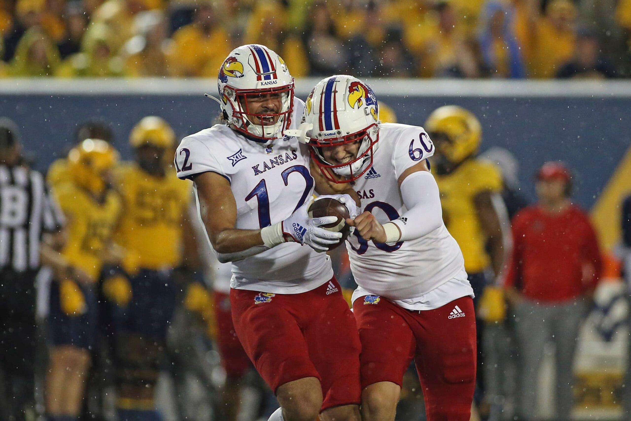Kansas running back Torry Locklin (12) and long snapper Luke Hosford (60) celebrate after Locklin recovered a fumble during the second half of an NCAA college football game against West Virginia in Morgantown, W.Va., Saturday, Sept. 10, 2022. (AP Photo/Kathleen Batten)
