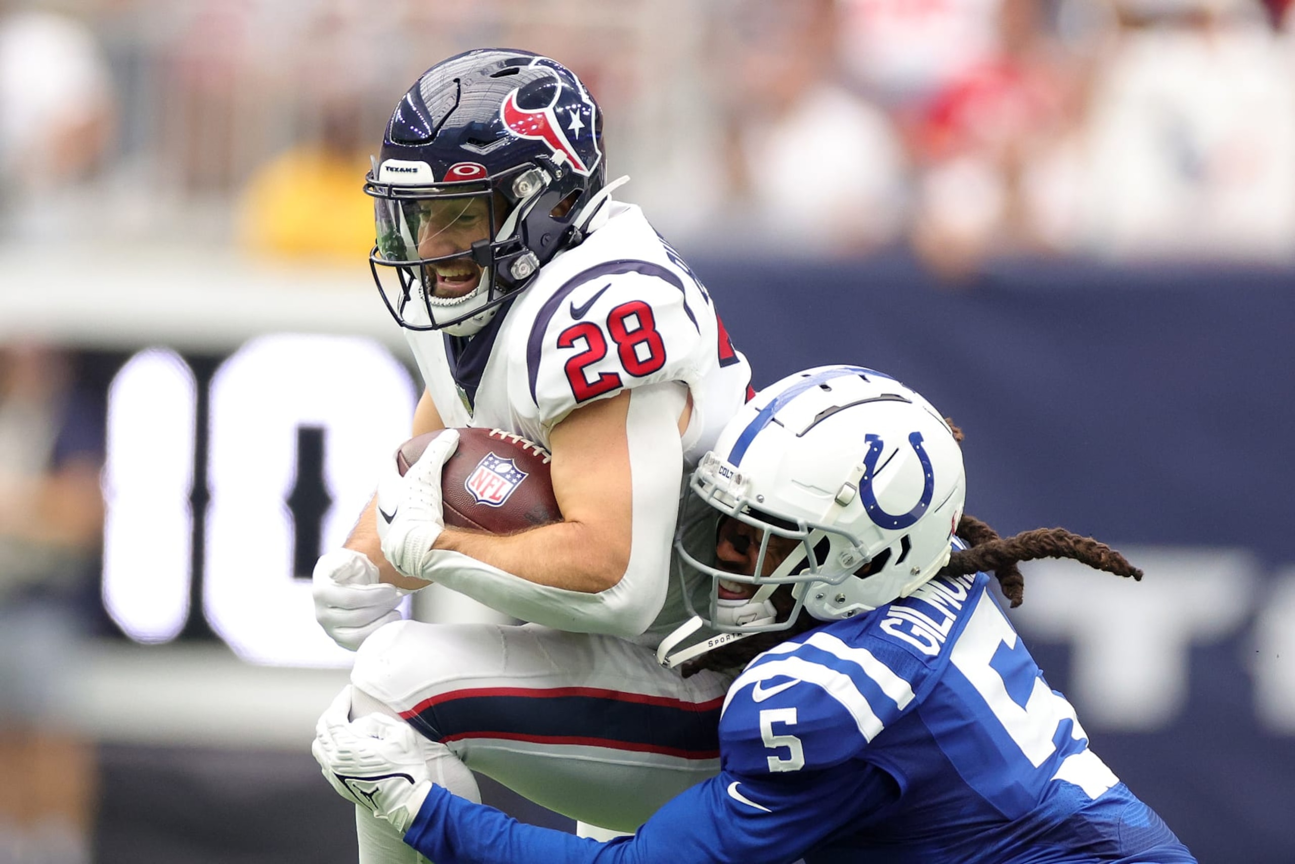 HOUSTON, TEXAS - SEPTEMBER 11: Rex Burkhead #28 of the Houston Texans is tackled by Stephon Gilmore #5 of the Indianapolis Colts during the second half at NRG Stadium on September 11, 2022 in Houston, Texas. (Photo by Carmen Mandato/Getty Images)
