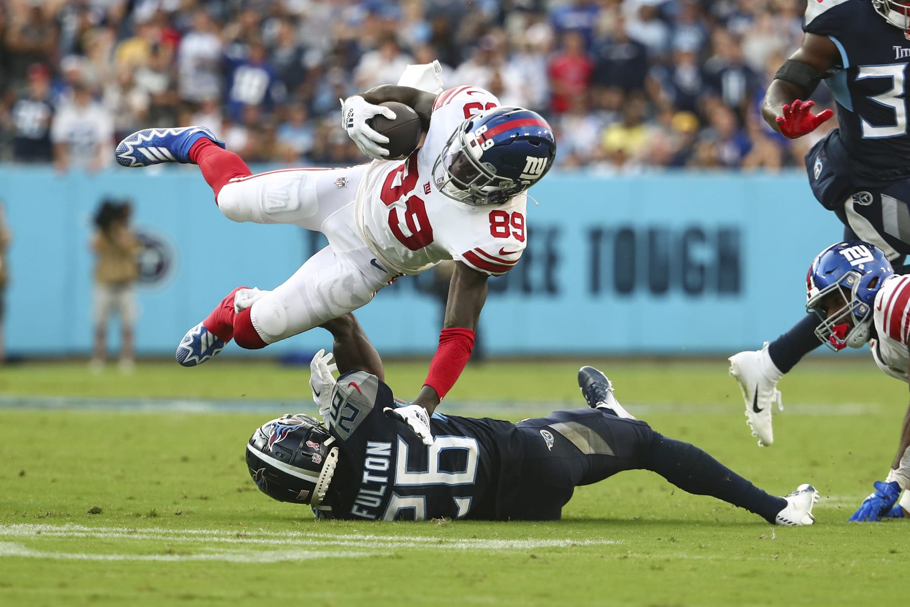 NASHVILLE, FL - SEPTEMBER 11: Kristian Fulton #26 of the Tennessee Titans tackles Kadarius Toney #89 of the New York Giants during an NFL football game at Nissan Stadium on September 11, 2022 in Nashville, Tennessee. (Photo by Kevin Sabitus/Getty Images)