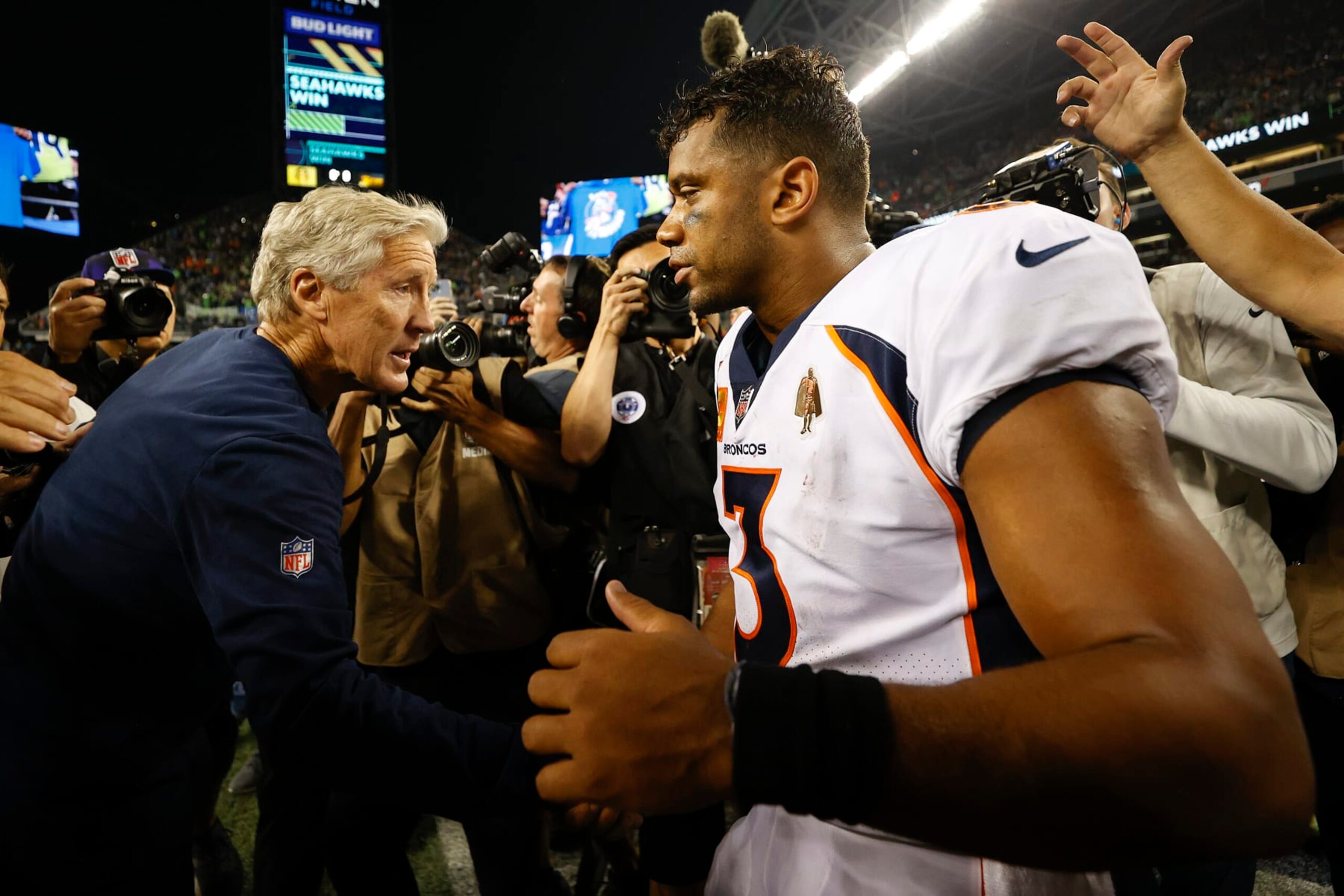 SEATTLE, WASHINGTON - SEPTEMBER 12: Head coach Pete Carroll of the Seattle Seahawks (L) and Russell Wilson #3 of the Denver Broncos shake hands after the Seahawks defeated the Broncos 17-16 at Lumen Field on September 12, 2022 in Seattle, Washington. (Photo by Steph Chambers/Getty Images) SEATTLE, WASHINGTON - SEPTEMBER 12: Head coach Pete Carroll of the Seattle Seahawks (L) and Russell Wilson #3 of the Denver Broncos shake hands after the Seahawks defeated the Broncos 17-16 at Lumen Field on September 12, 2022 in Seattle, Washington. (Photo by Steph Chambers/Getty Images)