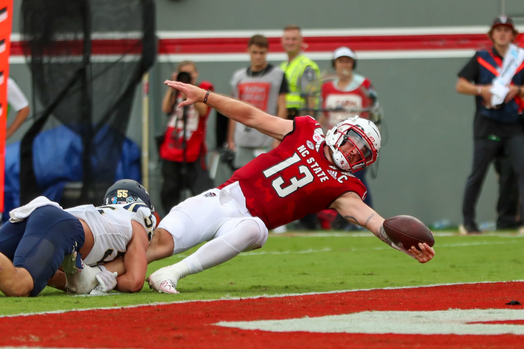 RALEIGH, NC - SEPTEMBER 10: Devin Leary (13) of the North Carolina State Wolfpack stretches out to score s touchdown during a football game between the North Carolina State Wolfpack and the Charleston Southern Buccaneers on September 10, 2022, at Carter-Finley Stadium in Raleigh, NC. (Photo by David Jensen/Icon Sportswire via Getty Images)