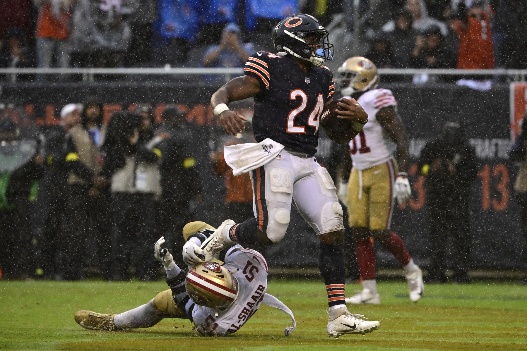 CHICAGO, ILLINOIS - SEPTEMBER 11: Running back Khalil Herbert #24 of the Chicago Bears runs over linebacker Azeez Al-Shaair #51 of the San Francisco 49ers while scoring a touchdown during the fourth quarter at Soldier Field on September 11, 2022 in Chicago, Illinois. (Photo by Quinn Harris/Getty Images)