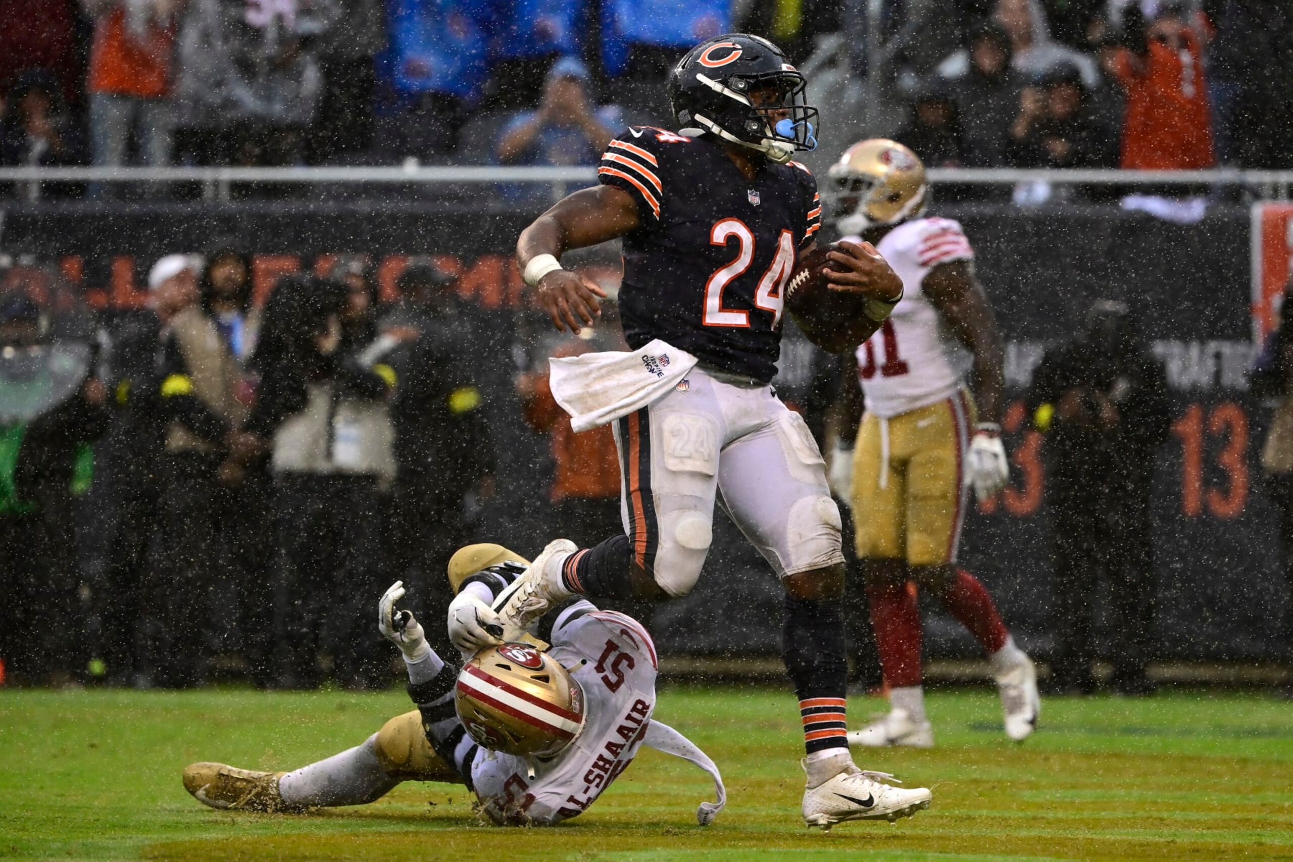 CHICAGO, ILLINOIS - SEPTEMBER 11: Running back Khalil Herbert #24 of the Chicago Bears runs over linebacker Azeez Al-Shaair #51 of the San Francisco 49ers while scoring a touchdown during the fourth quarter at Soldier Field on September 11, 2022 in Chicago, Illinois. (Photo by Quinn Harris/Getty Images)