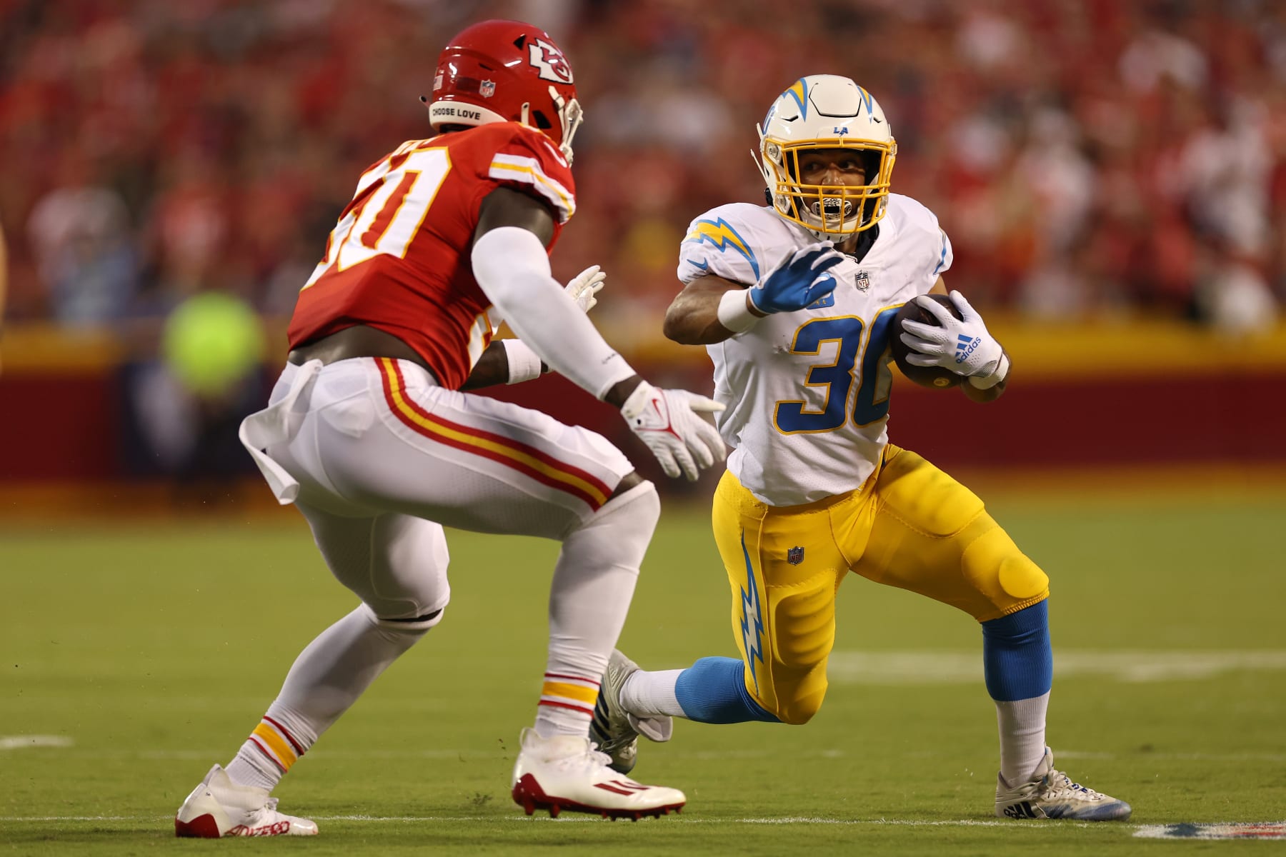 KANSAS CITY, MISSOURI - SEPTEMBER 15: Austin Ekeler #30 of the Los Angeles Chargers runs the ball against Willie Gay #50 of the Kansas City Chiefs during the first half at Arrowhead Stadium on September 15, 2022 in Kansas City, Missouri. (Photo by Jamie Squire/Getty Images)