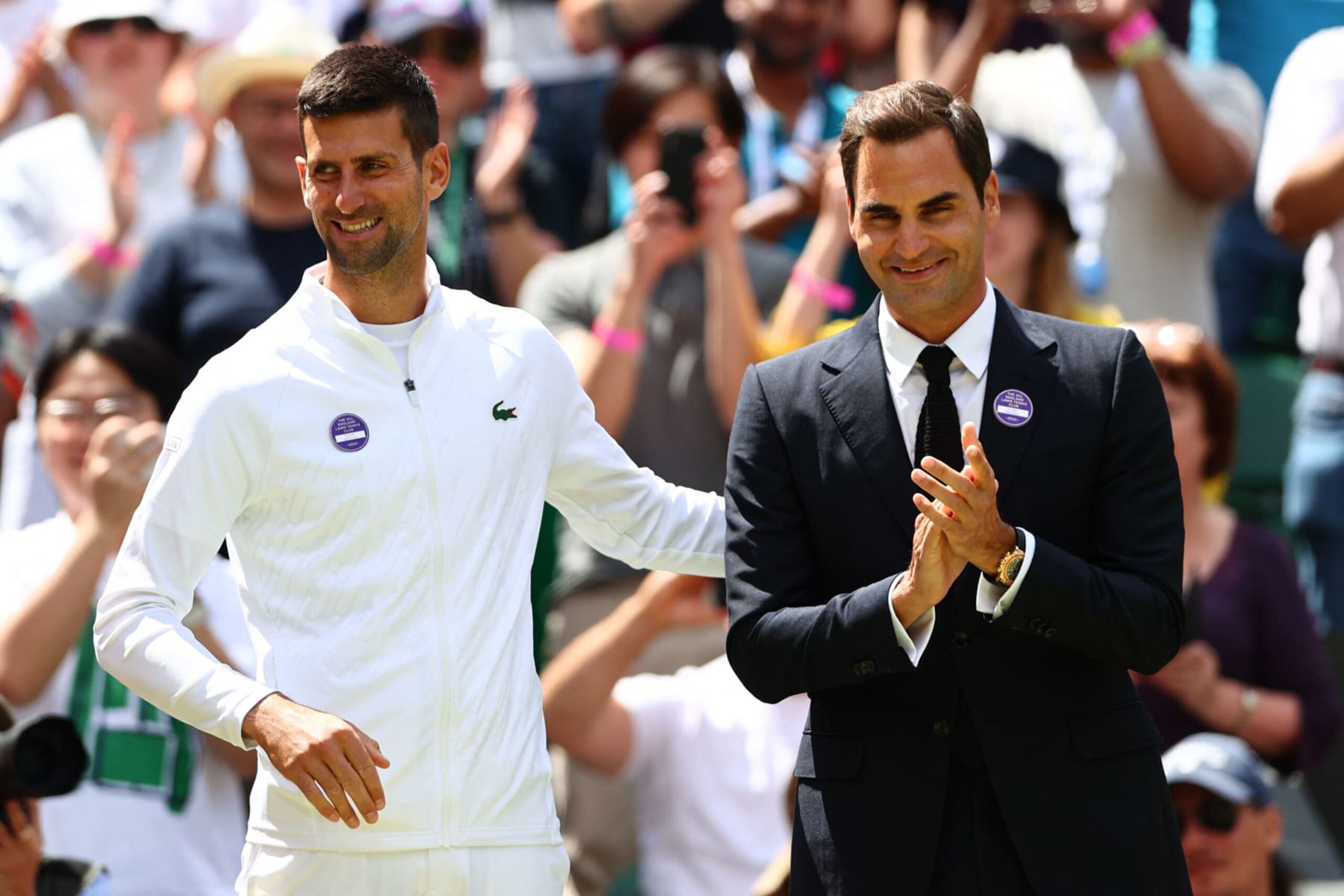 Swiss tennis player Roger Federer (R) and Serbia's Novak Djokovic take part in the Centre Court Centenary Ceremony, on the seventh day of the 2022 Wimbledon Championships at The All England Tennis Club in Wimbledon, southwest London, on July 3, 2022. - RESTRICTED TO EDITORIAL USE (Photo by Adrian DENNIS / AFP) / RESTRICTED TO EDITORIAL USE / The erroneous mention[s] appearing in the metadata of this photo by Adrian DENNIS has been modified in AFP systems in the following manner: [Swiss tennis player Roger Federer] instead of [Swiss former tennis player Roger Federer]. Please immediately remove the erroneous mention[s] from all your online services and delete it (them) from your servers. If you have been authorized by AFP to distribute it (them) to third parties, please ensure that the same actions are carried out by them. Failure to promptly comply with these instructions will entail liability on your part for any continued or post notification usage. Therefore we thank you very much for all your attention and prompt action. We are sorry for the inconvenience this notification may cause and remain at your disposal for any further information you may require. - RESTRICTED TO EDITORIAL USE (Photo by ADRIAN DENNIS/AFP via Getty Images)