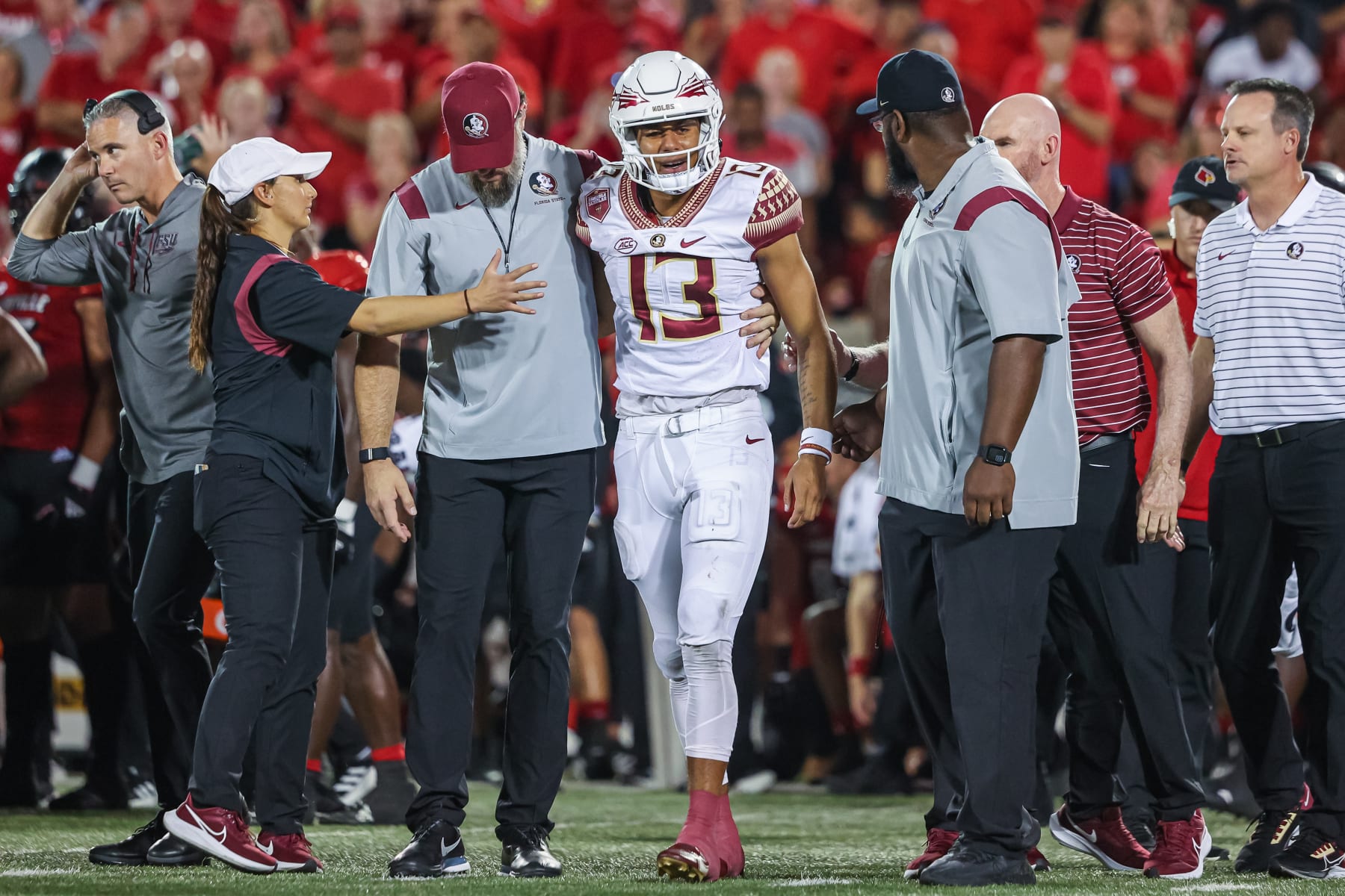 LOUISVILLE, KY - SEPTEMBER 16: Jordan Travis #13 of the Florida State Seminoles is assisted off the field during the first half against the Louisville Cardinals at Cardinal Stadium on September 16, 2022 in Louisville, Kentucky. (Photo by Michael Hickey/Getty Images)