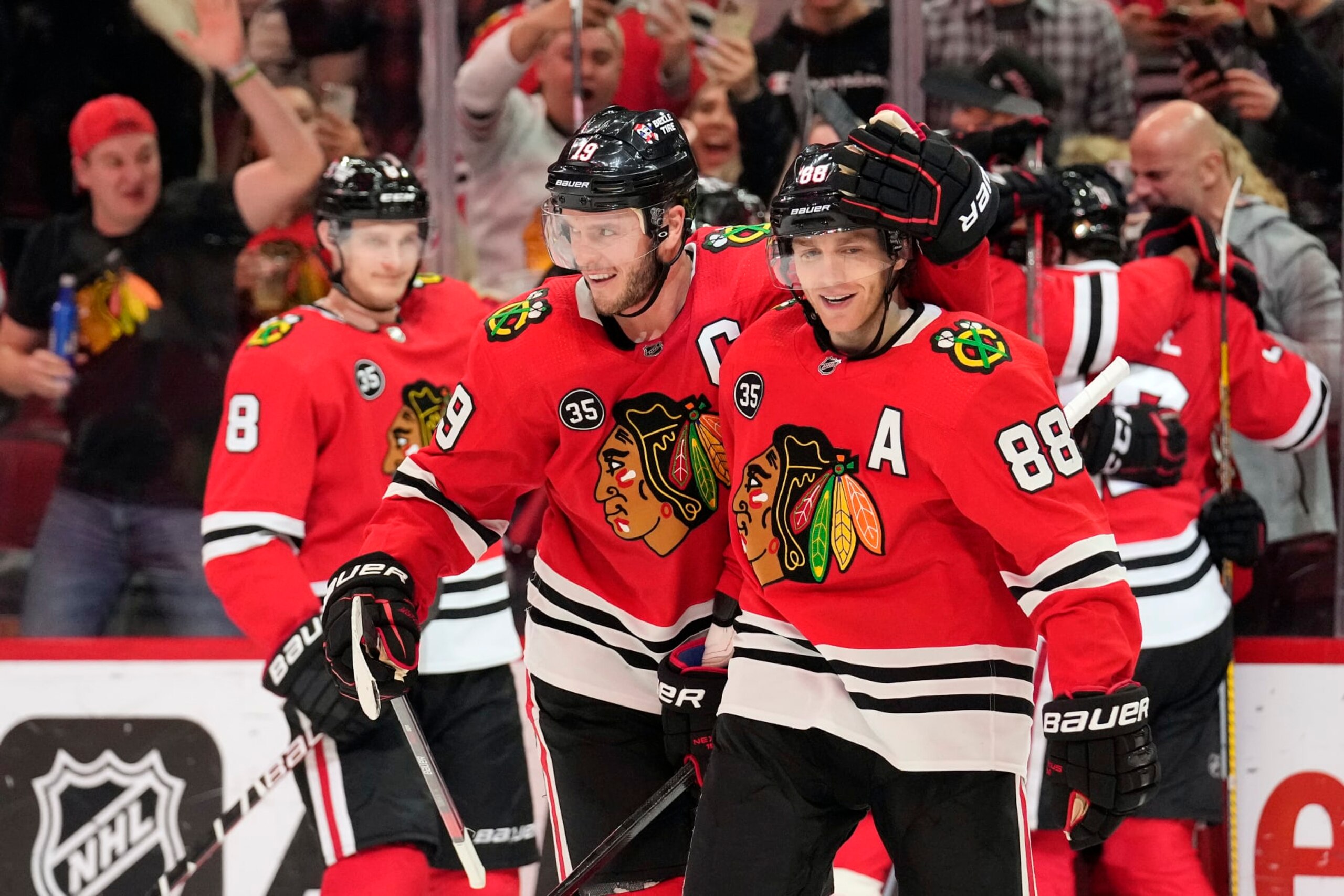 CHICAGO, ILLINOIS - MARCH 03: Jonathan Toews #19 and Patrick Kane #88 of the Chicago Blackhawks celebrate after Alex DeBrincat #12 scored the game-winning goal against the Edmonton Oilers during overtime at United Center on March 03, 2022 in Chicago, Illinois. The Chicago Blackhawks defeated the Edmonton Oilers 4-3 in overtime. (Photo by Patrick McDermott/Getty Images)