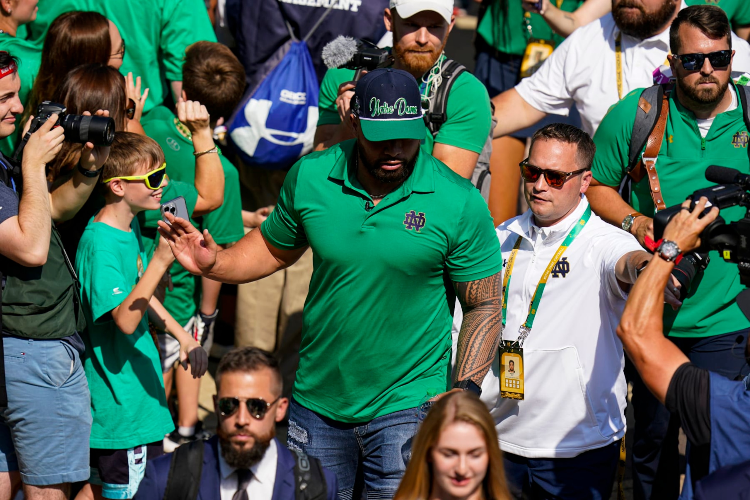 Former Notre Dame player Manti Te'o follows members of the Notre Dame football team walk through the crowd to the stadium before an NCAA college football game against California in South Bend, Ind., Saturday, Sept. 17, 2022. (AP Photo/Michael Conroy) Former Notre Dame player Manti Te'o follows members of the Notre Dame football team walk through the crowd to the stadium before an NCAA college football game against California in South Bend, Ind., Saturday, Sept. 17, 2022. (AP Photo/Michael Conroy)