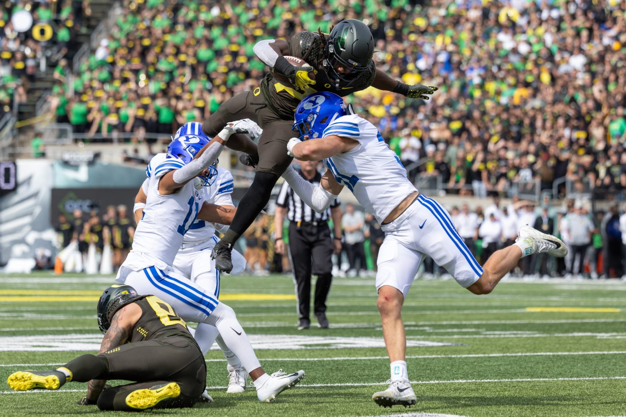 EUGENE, OR - SEPTEMBER 17: Running back Noah Whittington #22 of the Oregon Ducks leaps over linebacker Max Tooley #31 of the Brigham Young Cougars during the first half at Autzen Stadium on September 17, 2022 in Eugene, Oregon. (Photo by Tom Hauck/Getty Images) EUGENE, OR - SEPTEMBER 17: Running back Noah Whittington #22 of the Oregon Ducks leaps over linebacker Max Tooley #31 of the Brigham Young Cougars during the first half at Autzen Stadium on September 17, 2022 in Eugene, Oregon. (Photo by Tom Hauck/Getty Images)