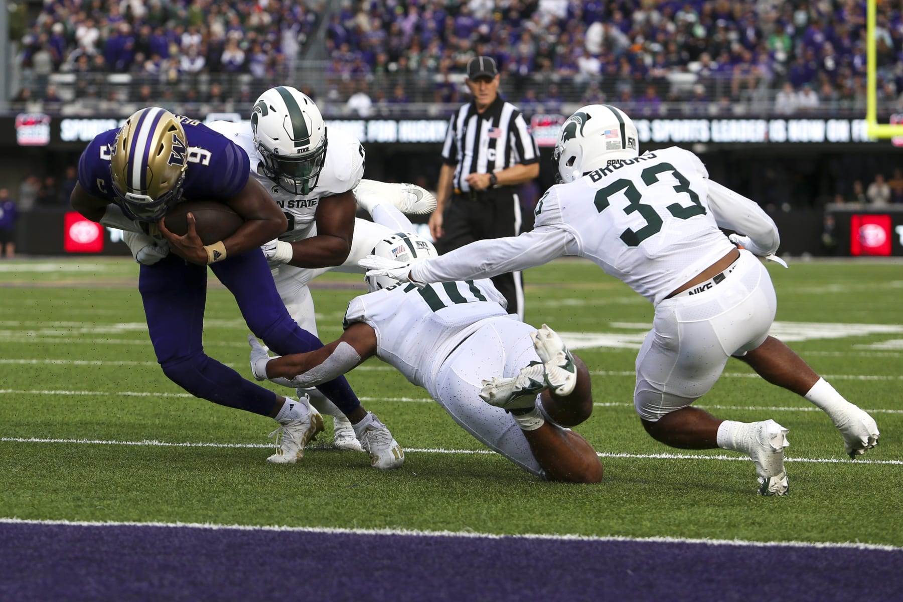 SEATTLE, WA - SEPTEMBER 17: Michigan State Spartans linebacker Quavian Carter (11) and Michigan State Spartans defensive end Khris Bogle (2) tackle Washington Huskies quarterback Michael Penix Jr. (9) short of the end zone during a college football game between the Michigan State Spartans and the Washington Huskies on September 17, 2022, at Husky Stadium in Seattle, WA. (Photo by Jacob Snow/Icon Sportswire via Getty Images)