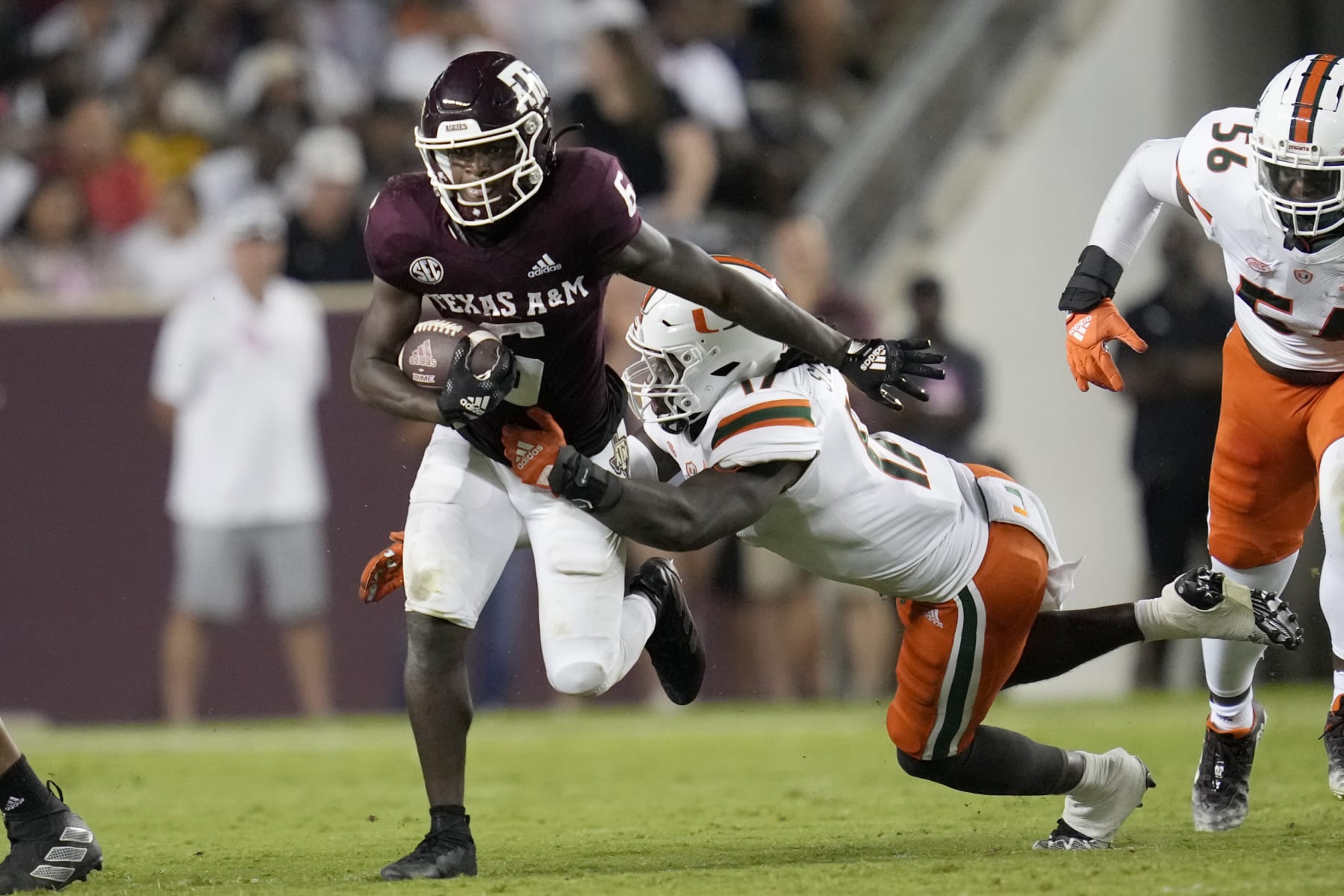 Texas A&M running back Devon Achane (6) breaks away from an attempted tackle by Miami linebacker Waynmon Steed Jr. (17) during the first half of an NCAA college football game Saturday, Sept. 17, 2022, in College Station, Texas. (AP Photo/Sam Craft)