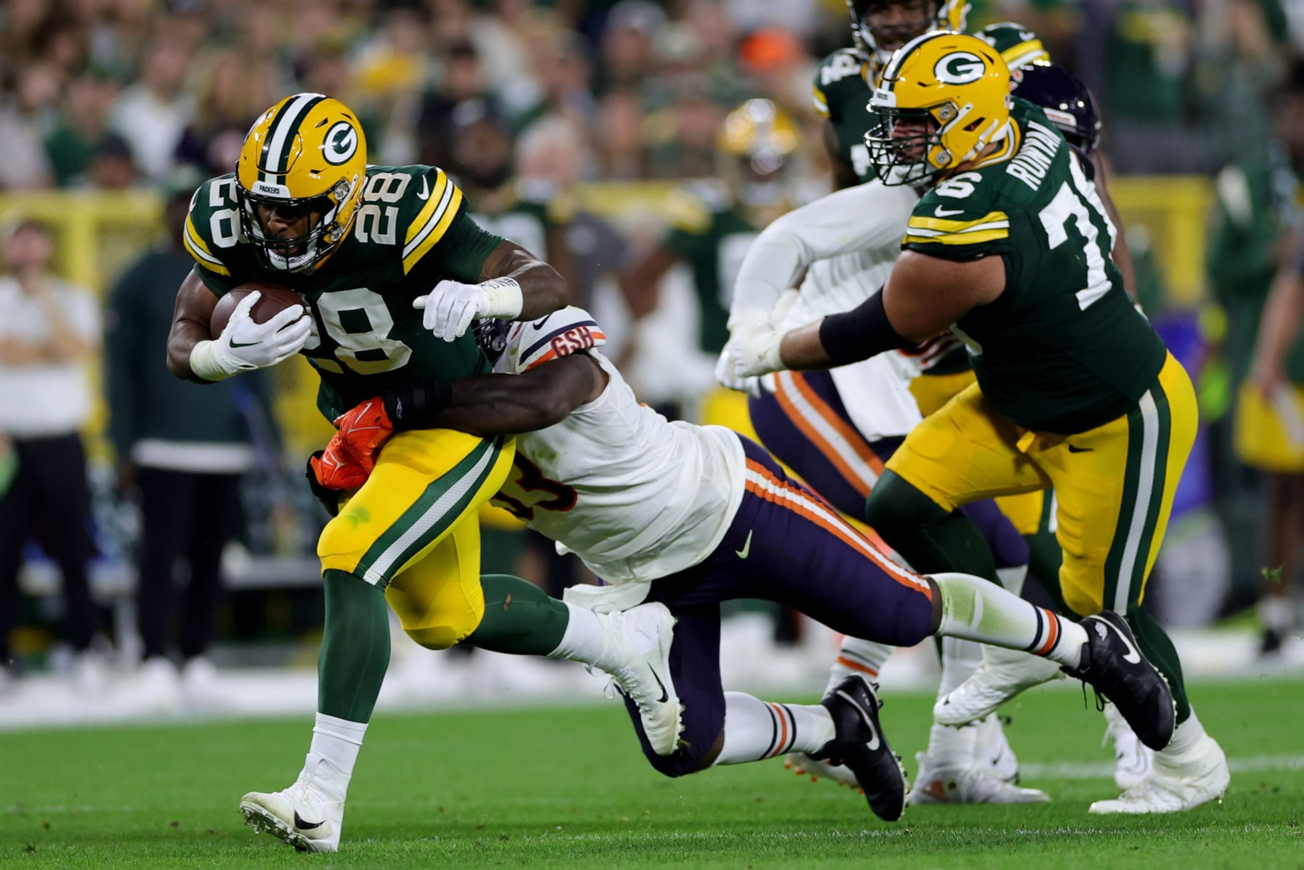 GREEN BAY, WISCONSIN - SEPTEMBER 18: AJ Dillon #28 of the Green Bay Packers is tackled by Justin Jones #93 of the Chicago Bears during the second quarter at Lambeau Field on September 18, 2022 in Green Bay, Wisconsin. (Photo by Stacy Revere/Getty Images)