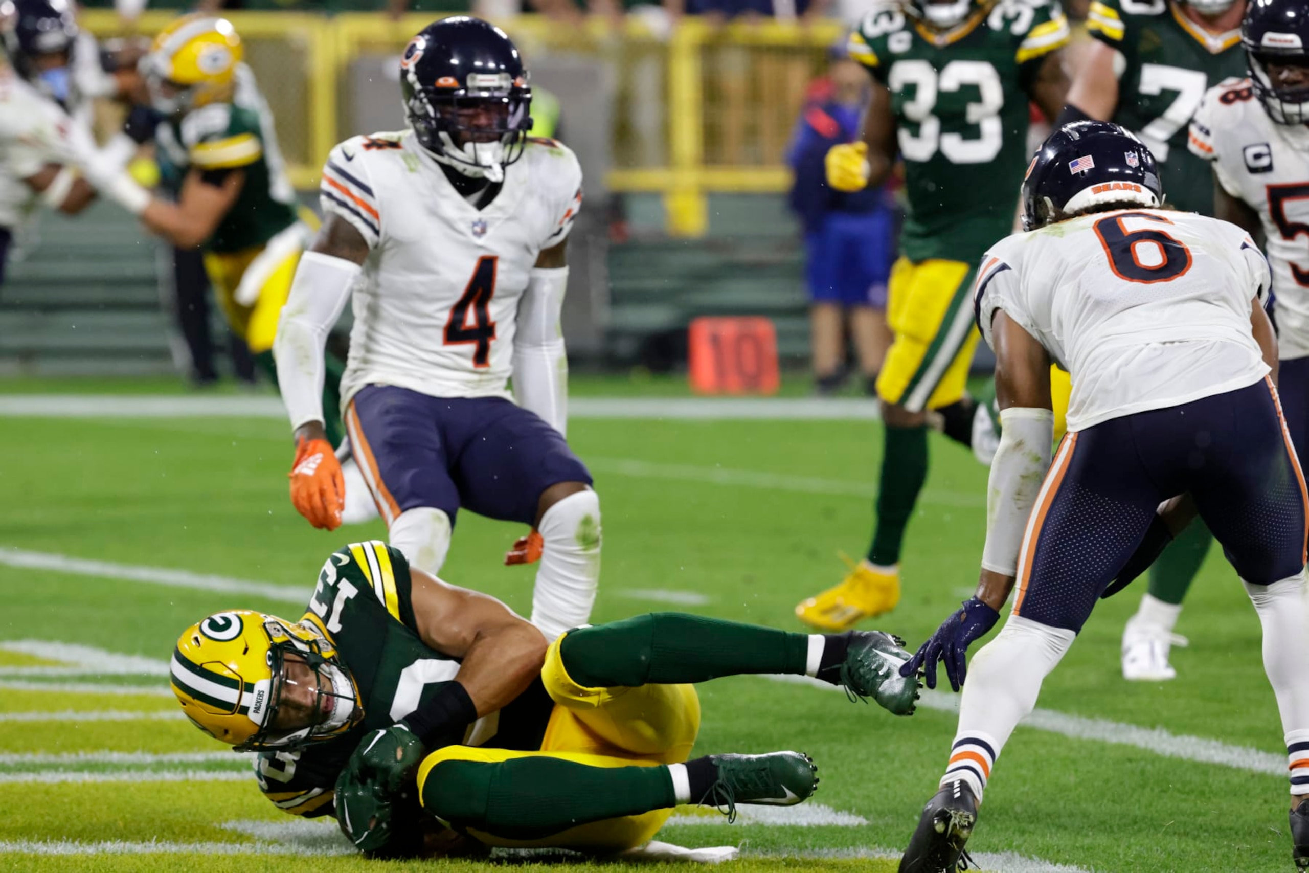 Green Bay Packers wide receiver Allen Lazard (13) catches a 5-yard touchdown pass between Chicago Bears safety Eddie Jackson (4) and cornerback Kyler Gordon (6) during the first half of an NFL football game Sunday, Sept. 18, 2022, in Green Bay, Wis. (AP Photo/Mike Roemer)