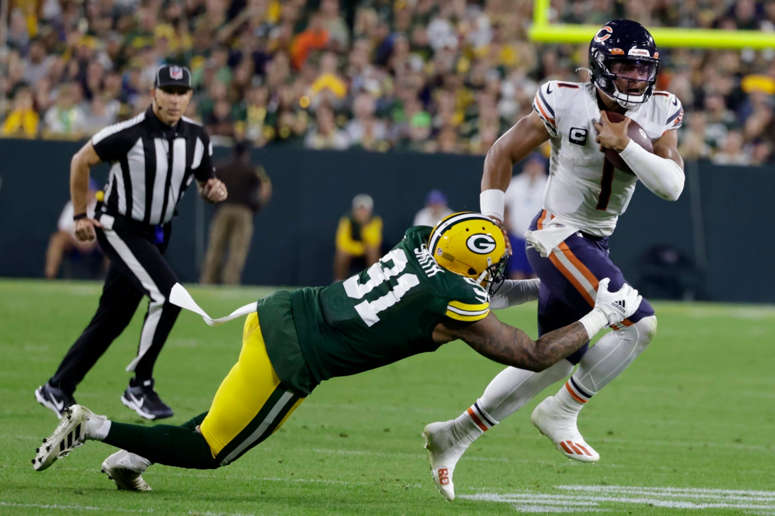 Chicago Bears quarterback Justin Fields (1) tries to break a tackle by Green Bay Packers linebacker Preston Smith (91) during the second half of an NFL football game Sunday, Sept. 18, 2022, in Green Bay, Wis. (AP Photo/Matt Ludtke)