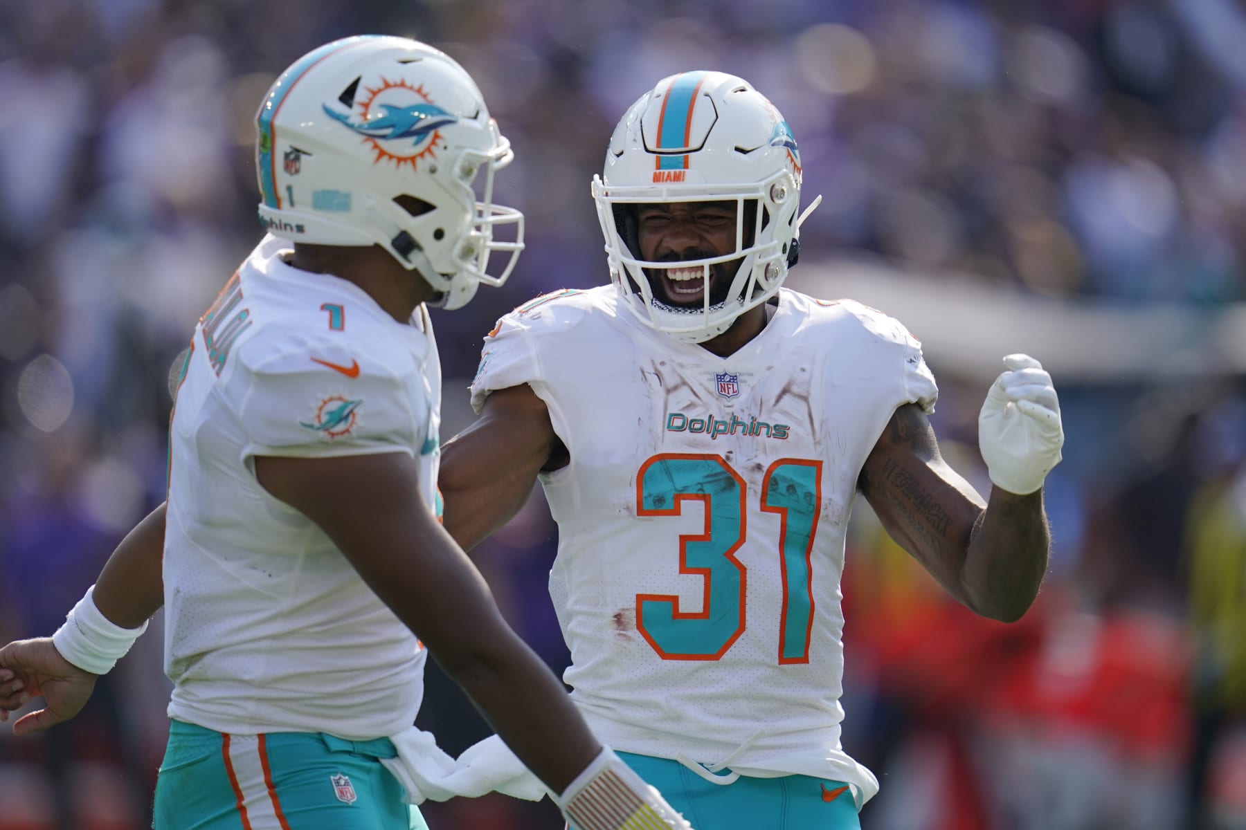 Miami Dolphins running back Raheem Mostert (31) and quarterback Tua Tagovailoa (1) celebrate a touchdown during the second half of an NFL football game against the Baltimore Ravens, Sunday, Sept. 18, 2022, in Baltimore. (AP Photo/Julio Cortez)