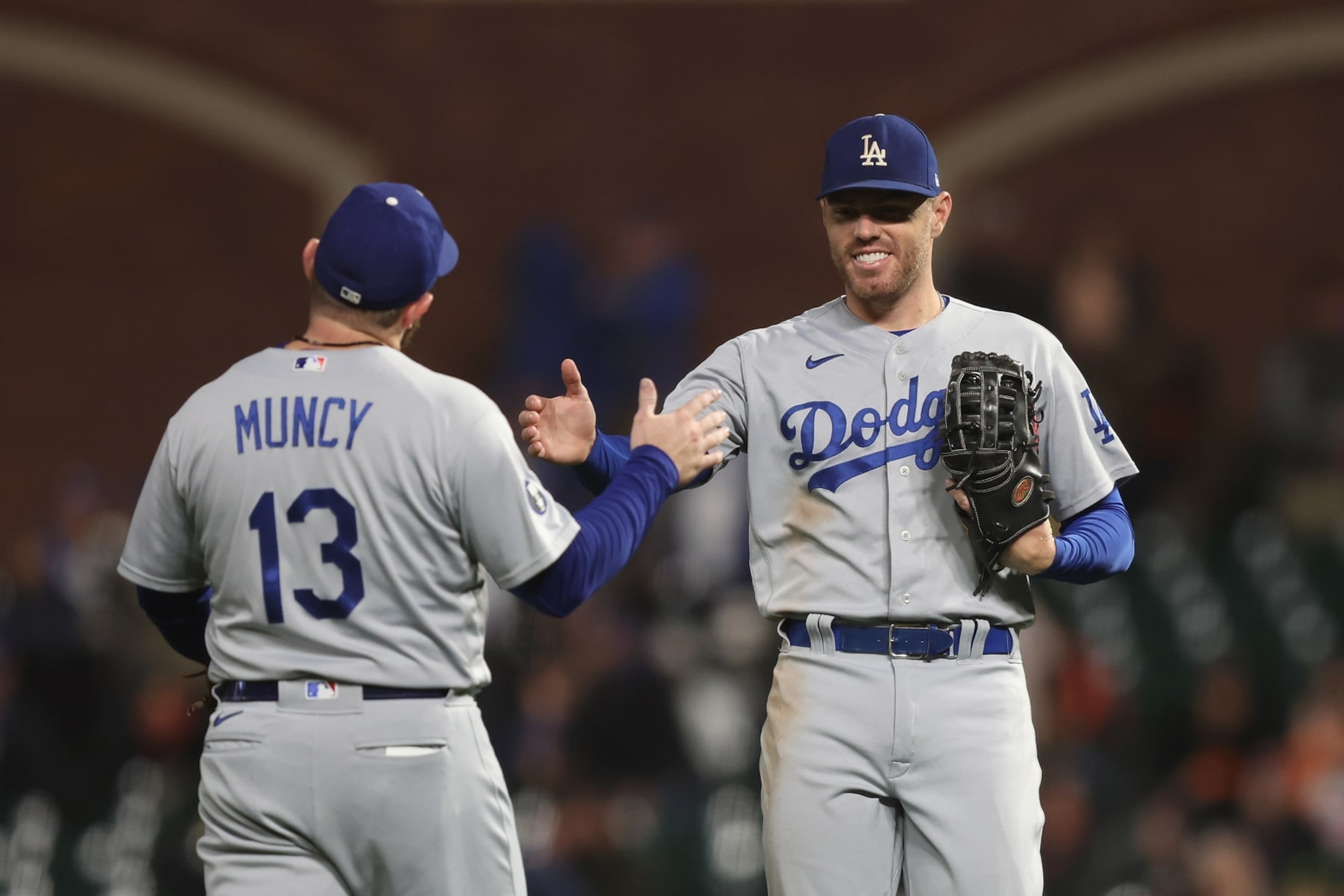 SAN FRANCISCO, CALIFORNIA - SEPTEMBER 17: Max Muncy #13 and Freddie Freeman #5 of the Los Angeles Dodgers celebrate after a win against the San Francisco Giants at Oracle Park on September 17, 2022 in San Francisco, California. (Photo by Lachlan Cunningham/Getty Images)