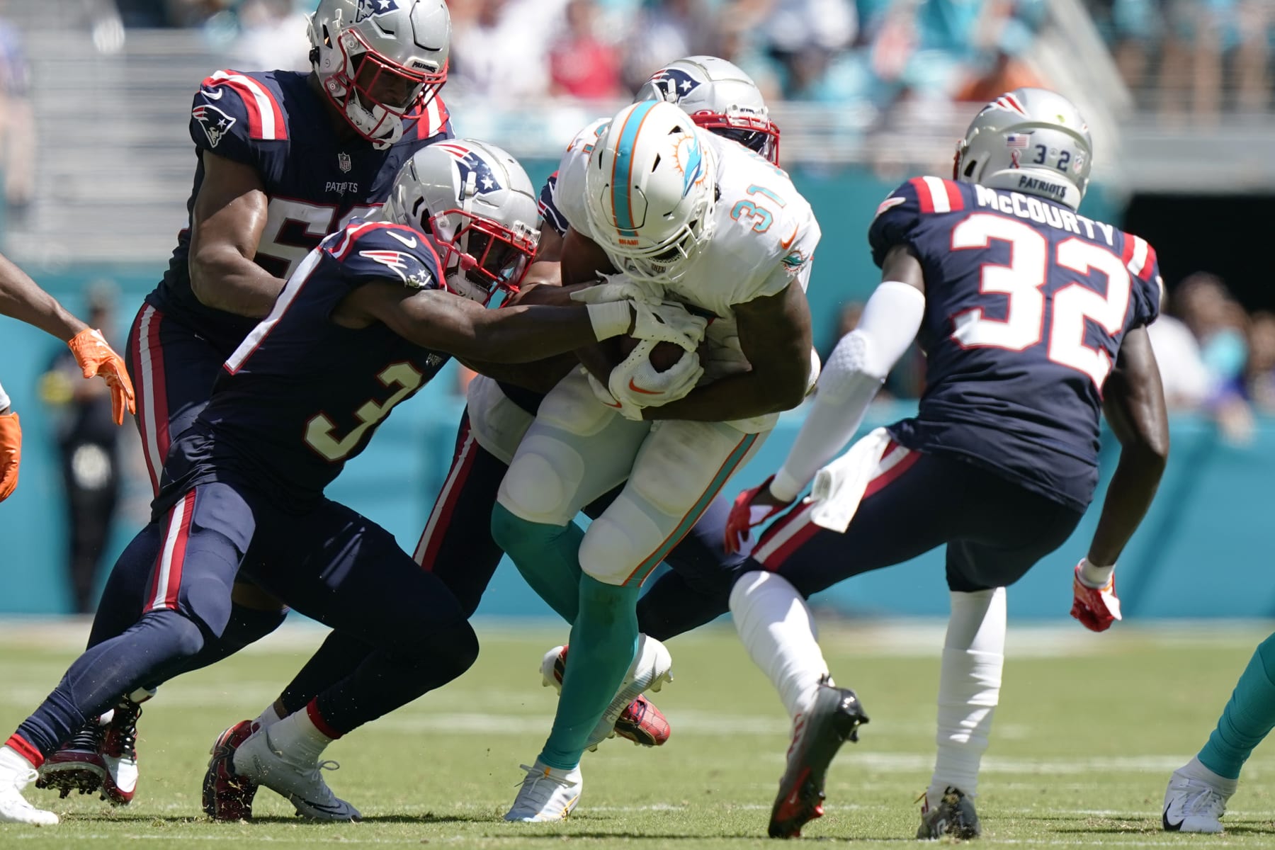 New England Patriots cornerback Jonathan Jones (31) tackles Miami Dolphins running back Raheem Mostert (31) during the second half of an NFL football game, Sunday, Sept. 11, 2022, in Miami Gardens, Fla. (AP Photo/Lynne Sladky)