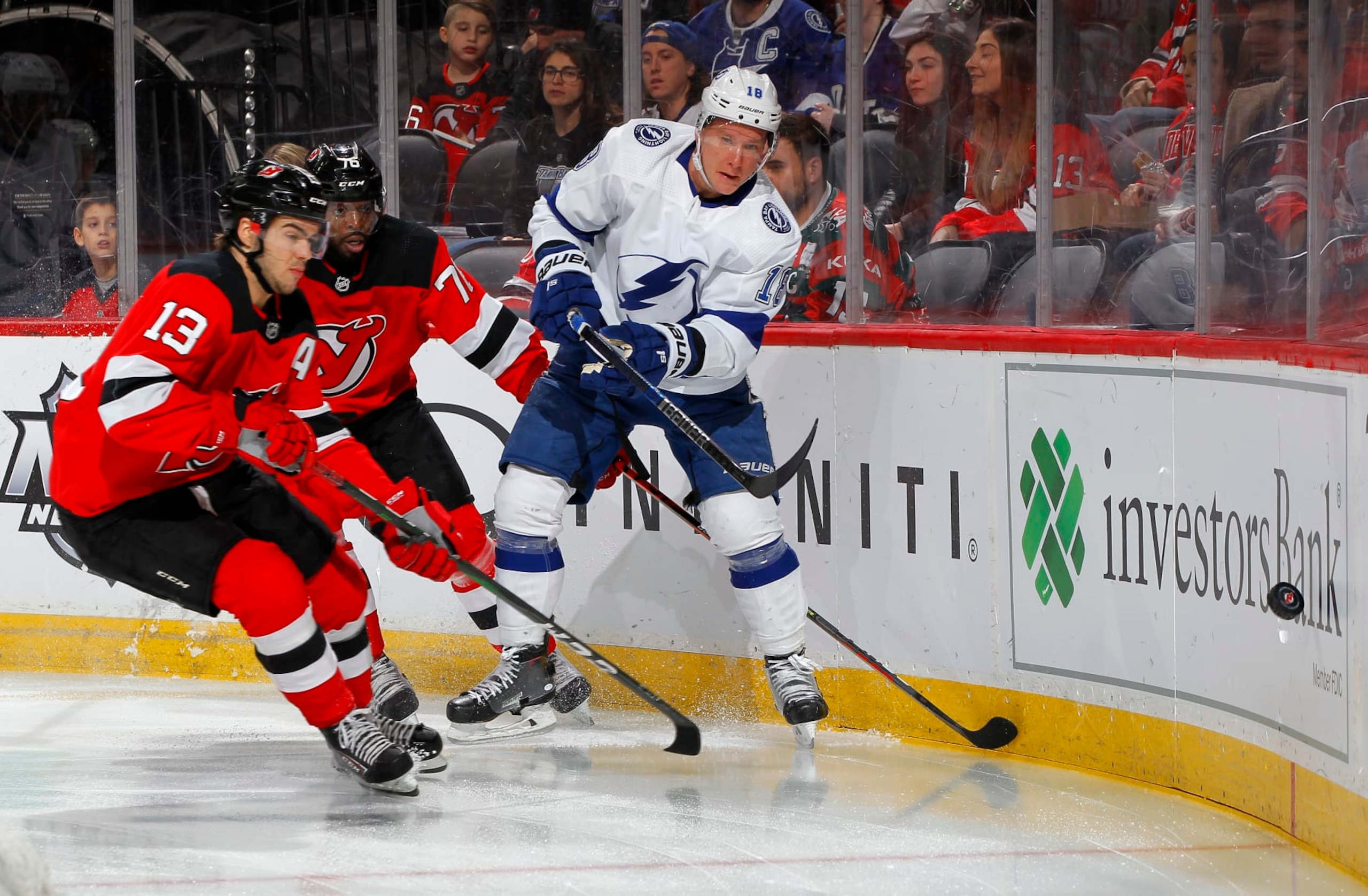 NEWARK, NEW JERSEY - JANUARY 12:   Ondrej Palat #18 of the Tampa Bay Lightning clears the puck away from Nico Hischier #13 and P.K. Subban #76 of the New Jersey Devils during the first period at Prudential Center on January 12, 2020 in Newark, New Jersey. (Photo by Jim McIsaac/Getty Images)