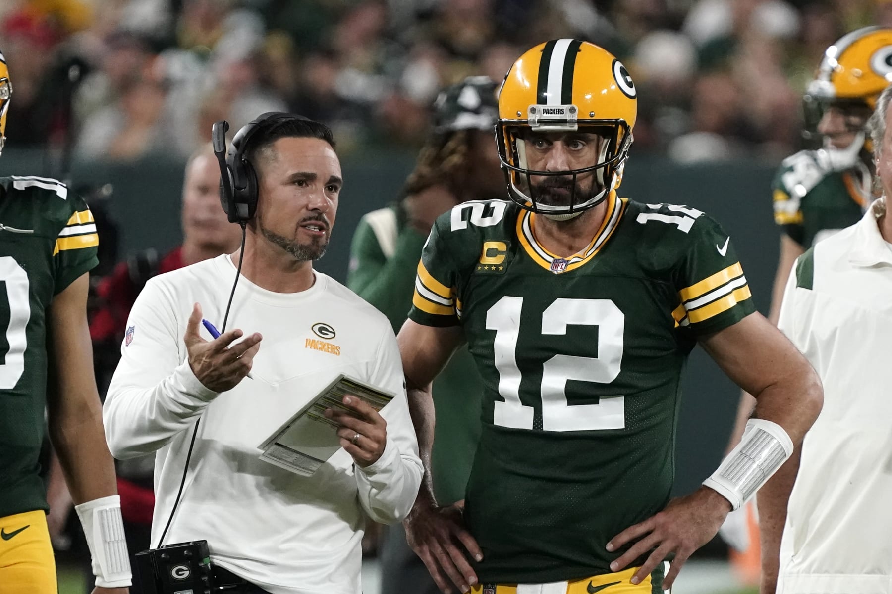 Green Bay Packers head coach Matt LaFleur talks with quarterback Aaron Rodgers (12) during the first half of an NFL football game against the Chicago Bears Sunday, Sept. 18, 2022, in Green Bay, Wis. (AP Photo/Morry Gash)