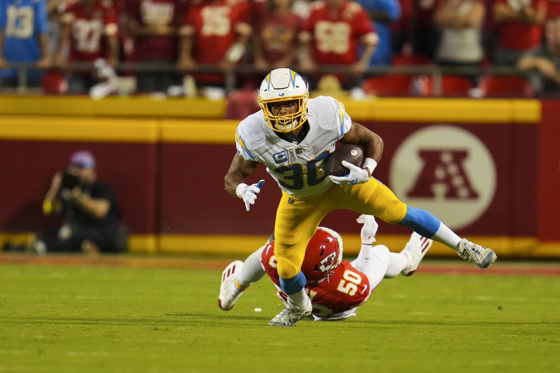 KANSAS CITY, MO - SEPTEMBER 15: Austin Ekeler #30 of the Los Angeles Chargers escapes the tackle by Kansas City Chiefs linebacker Willie Gay (50) at GEHA Field at Arrowhead Stadium on September 15, 2022 in Kansas City, Missouri. (Photo by Cooper Neill/Getty Images)