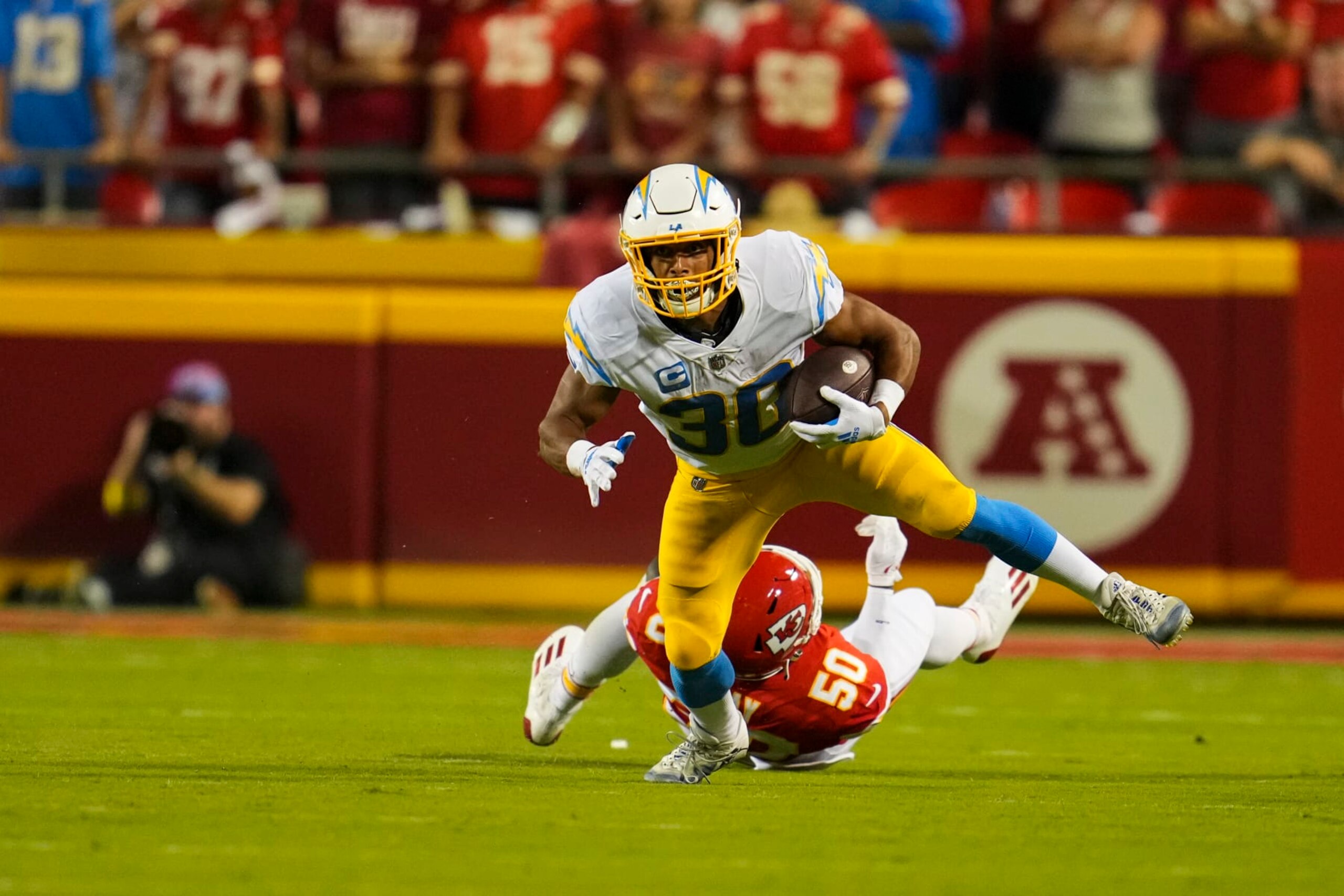 KANSAS CITY, MO - SEPTEMBER 15: Austin Ekeler #30 of the Los Angeles Chargers escapes the tackle by Kansas City Chiefs linebacker Willie Gay (50) at GEHA Field at Arrowhead Stadium on September 15, 2022 in Kansas City, Missouri. (Photo by Cooper Neill/Getty Images)