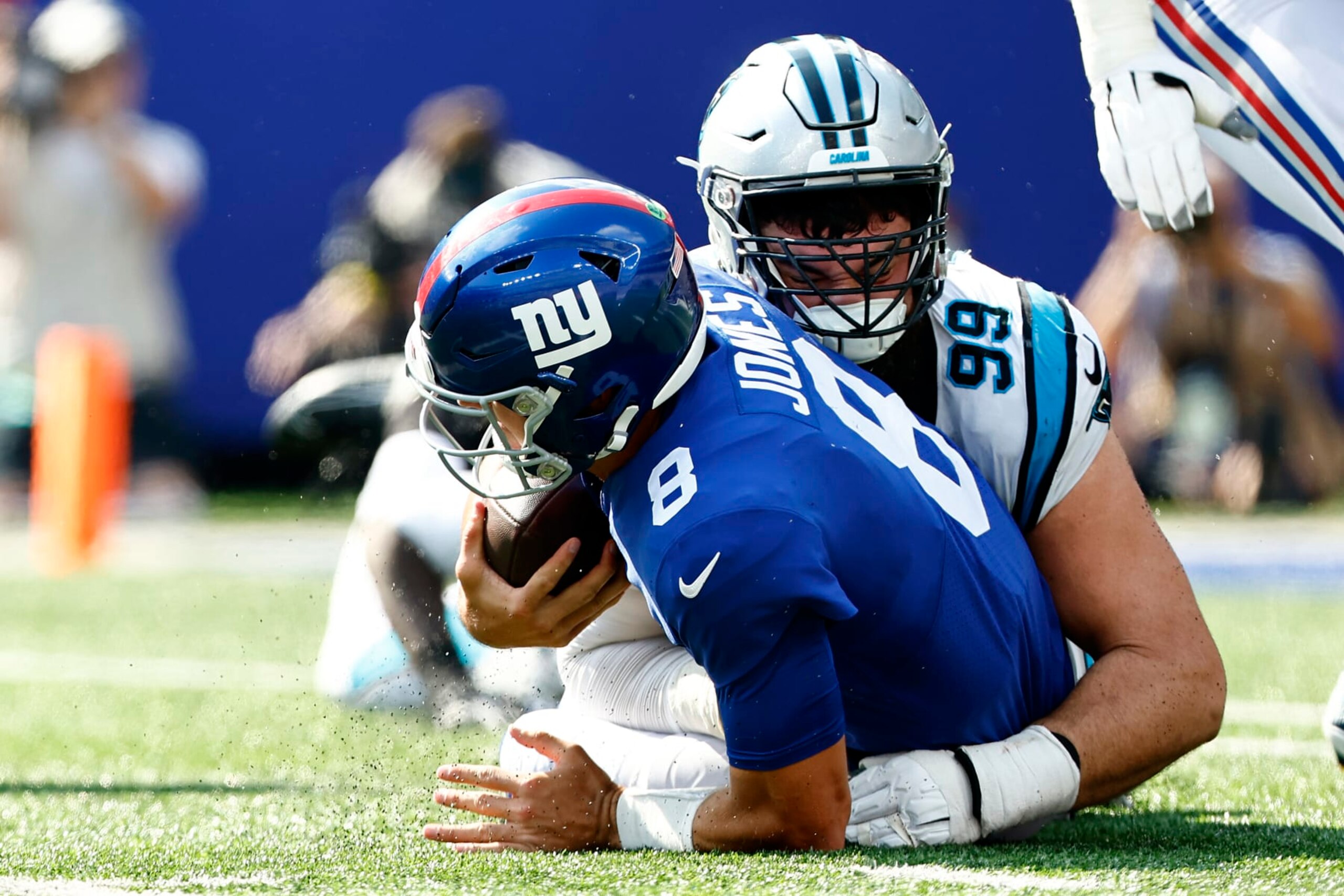 EAST RUTHERFORD, NEW JERSEY - SEPTEMBER 18: Daniel Jones #8 of the New York Giants is sacked by Matt Ioannidis #99 of the Carolina Panthers in the second half of the game at MetLife Stadium on September 18, 2022 in East Rutherford, New Jersey. (Photo by Rich Schultz/Getty Images)