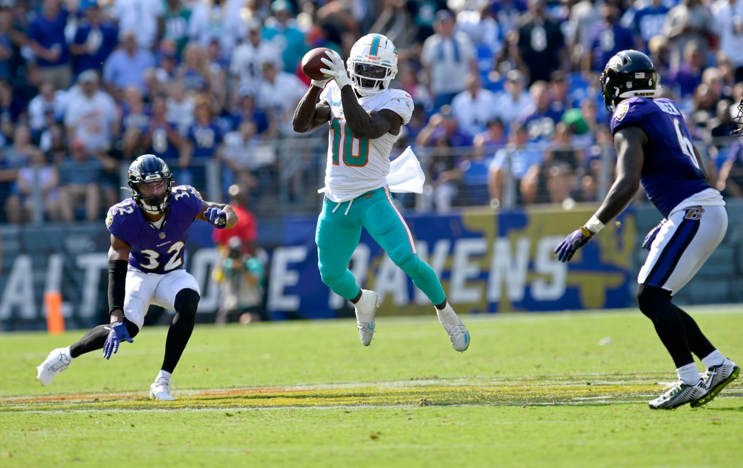BALTIMORE, MD - SEPTEMBER 18: Miami Dolphins wide receiver Tyreek Hill (10) makes a leaping catch between two defenders during the Miami Dolphins versus Baltimore Ravens NFL game at M&T Bank Stadium on September 18, 2022 in Baltimore, MD (Photo by Randy Litzinger/Icon Sportswire via Getty Images)