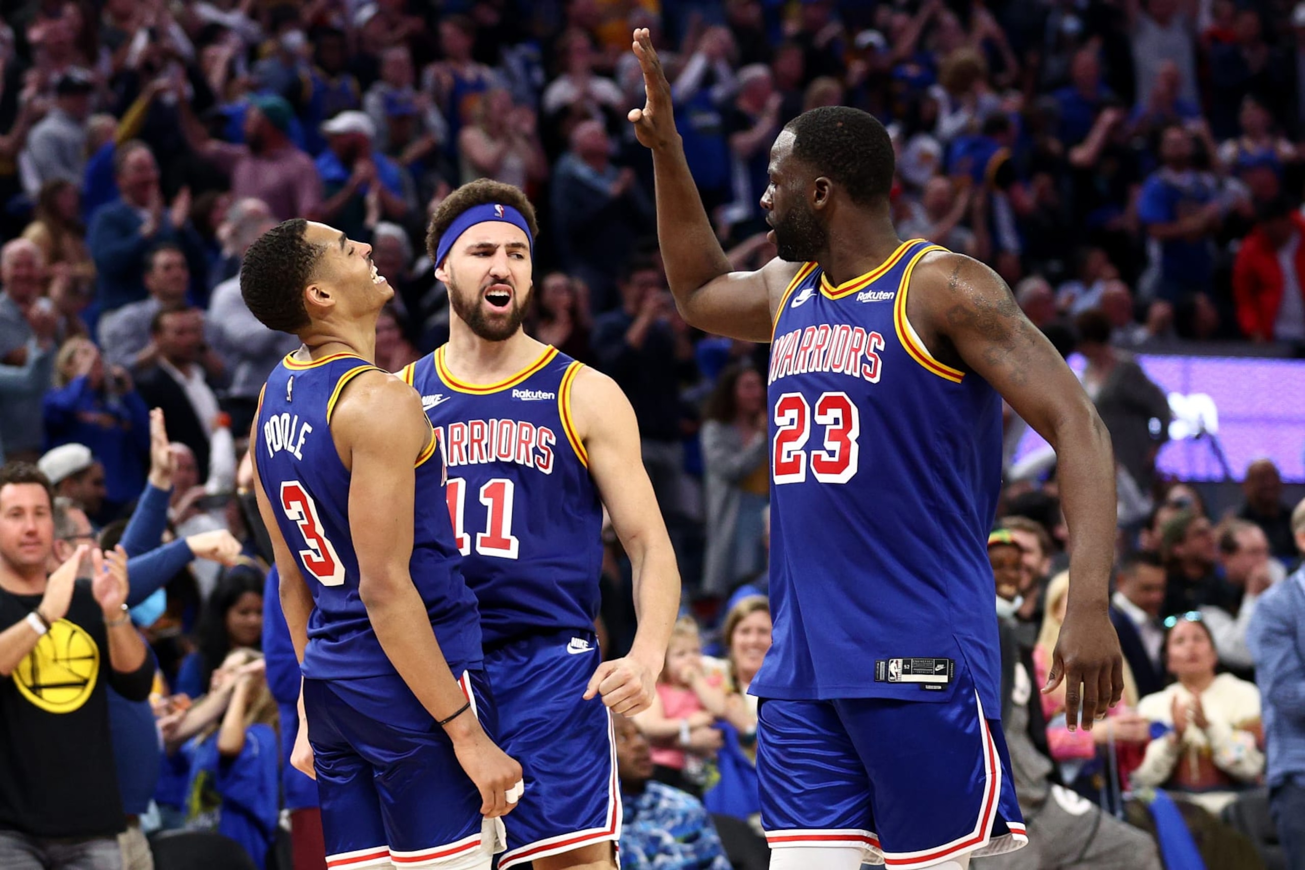 SAN FRANCISCO, CALIFORNIA - APRIL 02:  Jordan Poole #3 of the Golden State Warriors is congratulated by Klay Thompson #11 and Draymond Green #23 after making a three point basket against the Utah Jazz in the fourth quarter at Chase Center on April 02, 2022 in San Francisco, California. NOTE TO USER: User expressly acknowledges and agrees that, by downloading and/or using this photograph, User is consenting to the terms and conditions of the Getty Images License Agreement.  (Photo by Ezra Shaw/Getty Images)