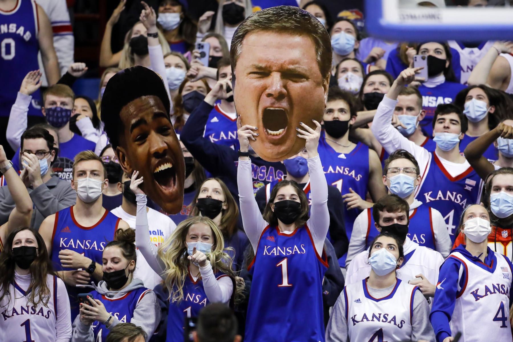 Masked Jayhawk fans hold photo heads of Kansas guard Ochai Agbaji and head coach Bill Self during an NCAA college basketball game against Texas Tech on Monday, Jan. 24, 2022 in Lawrence, Kan. (AP Photo/Colin E. Braley)