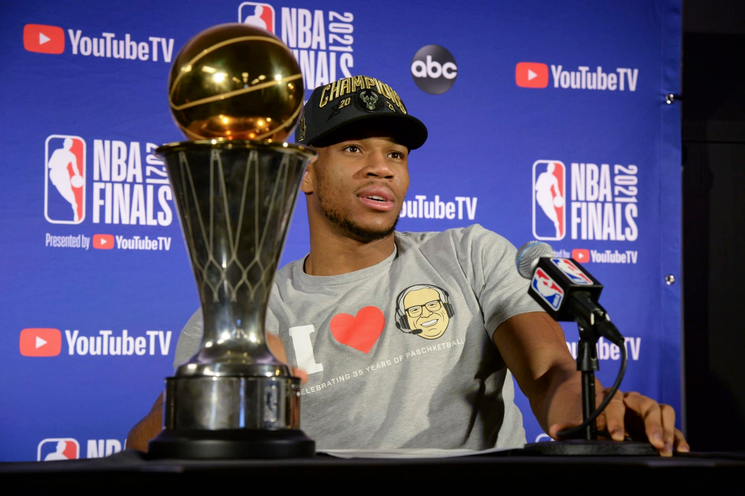 MILWAUKEE, WI - JULY 20: Giannis Antetokounmpo #34 of the Milwaukee Bucks holds the Bill Russell NBA Finals MVP Award and Larry O'Brien Trophy as he talks to the media after defeating the Phoenix Suns in Game Six to win the 2021 NBA Finals  on July 20, 2021 at the Fiserv Forum in Milwaukee, Wisconsin. NOTE TO USER: User expressly acknowledges and agrees that, by downloading and or using this Photograph, user is consenting to the terms and conditions of the Getty Images License Agreement. Mandatory Copyright Notice: Copyright 2021 NBAE (Photo by Andrew D. Bernstein/NBAE via Getty Images).