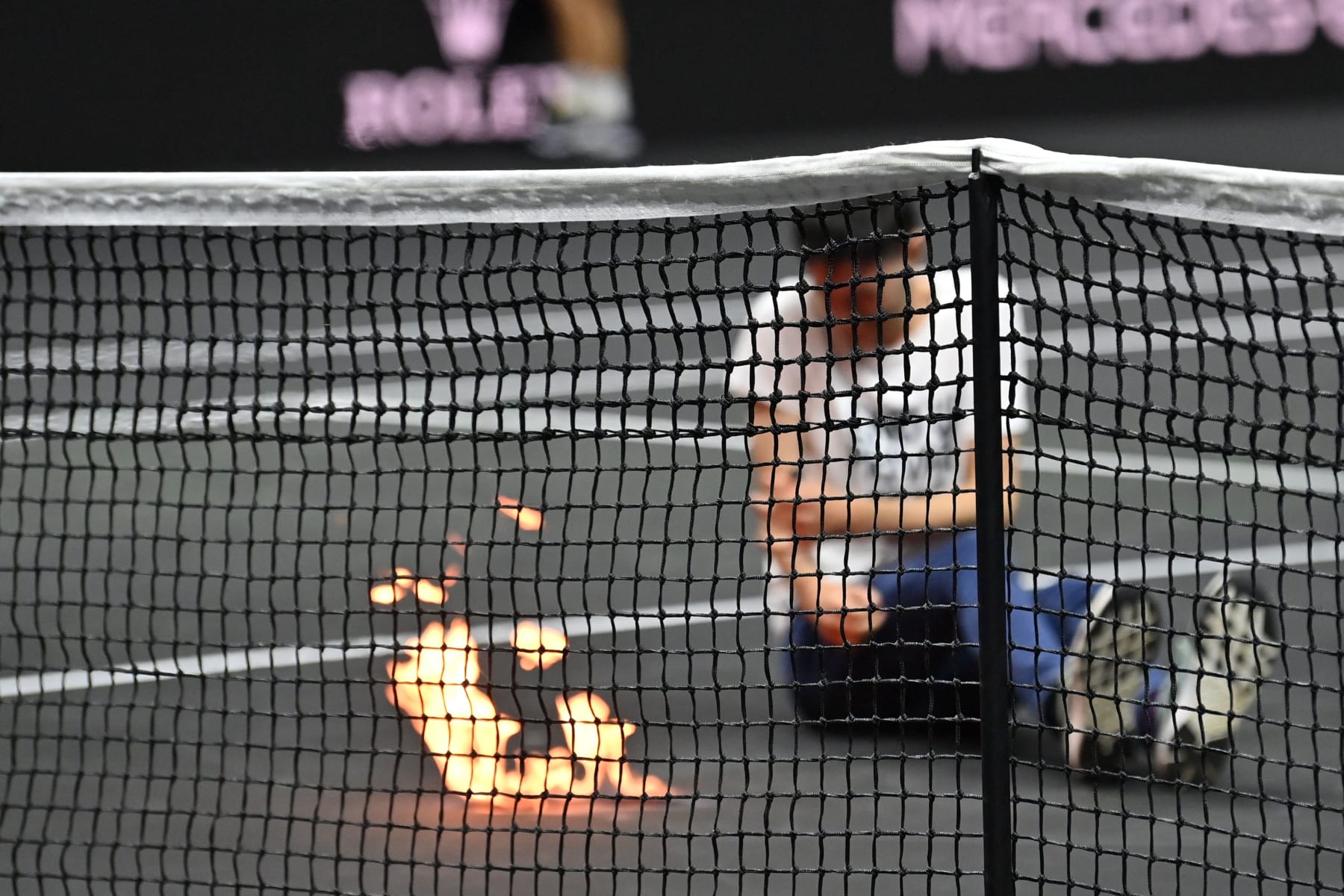 A protester invades the court, appearing to set his arm alight during the singles game between Greece's Stefanos Tsitsipas of Team Europe and Argentina's Diego Schwartzman of Team World at the 2022 Laver Cup at the O2 Arena in London on September 23, 2022. - RESTRICTED TO EDITORIAL USE (Photo by Glyn KIRK / AFP) / RESTRICTED TO EDITORIAL USE (Photo by GLYN KIRK/AFP via Getty Images)