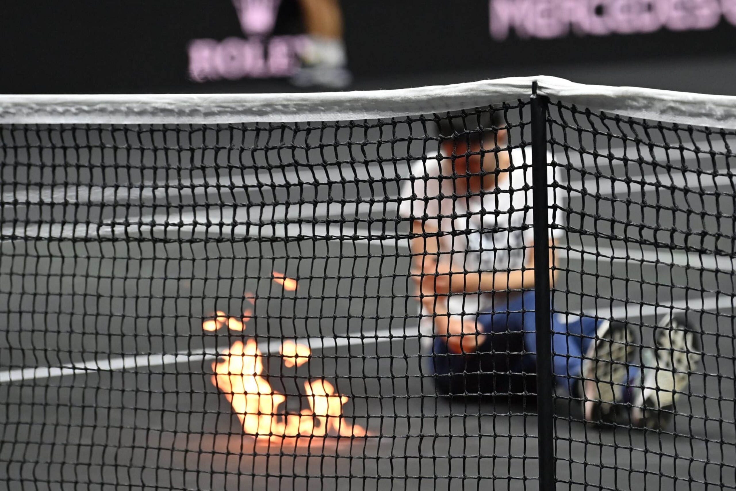 A protester invades the court, appearing to set his arm alight during the singles game between Greece's Stefanos Tsitsipas of Team Europe and Argentina's Diego Schwartzman of Team World at the 2022 Laver Cup at the O2 Arena in London on September 23, 2022. - RESTRICTED TO EDITORIAL USE (Photo by Glyn KIRK / AFP) / RESTRICTED TO EDITORIAL USE (Photo by GLYN KIRK/AFP via Getty Images)
