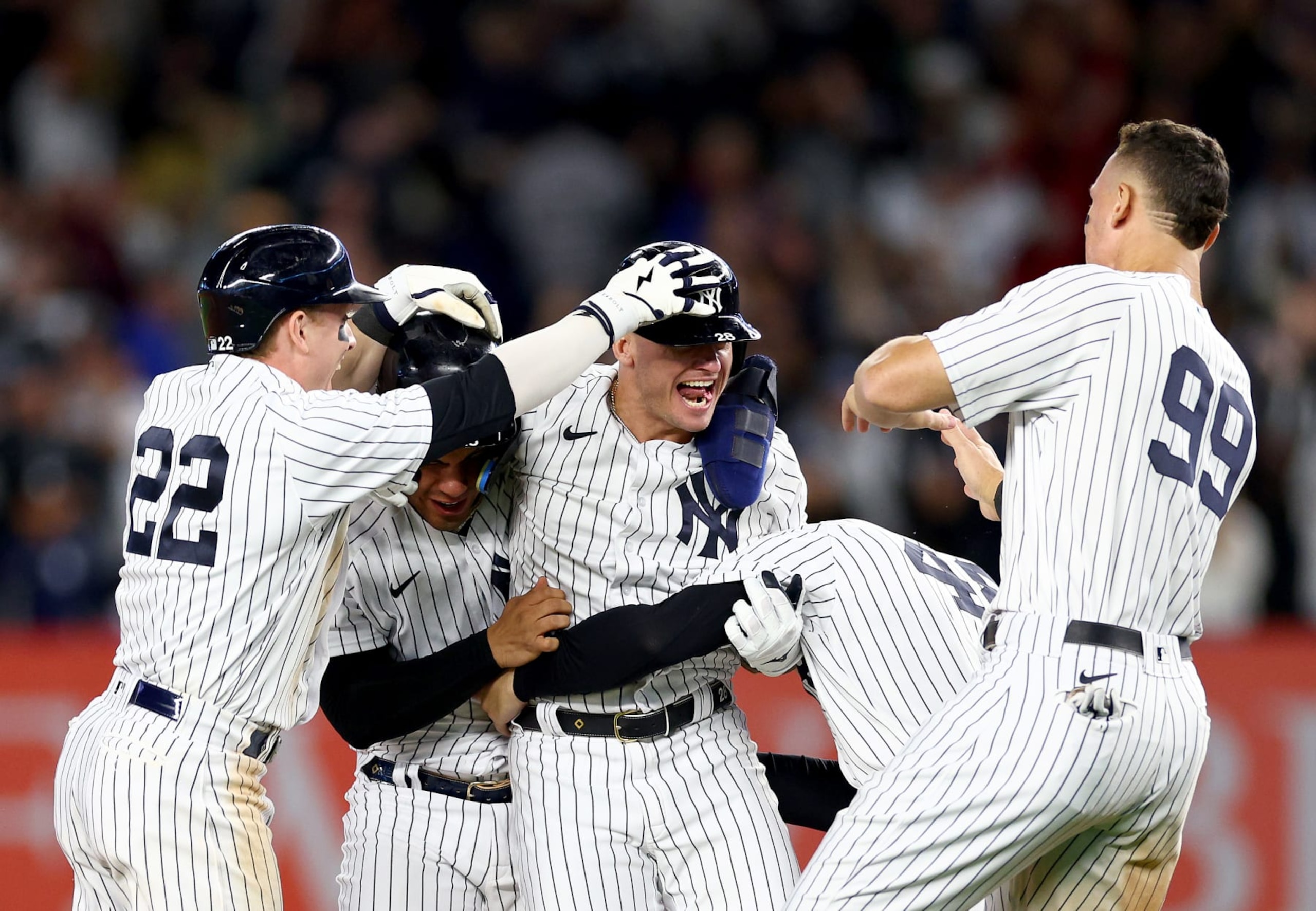 NEW YORK, NEW YORK - SEPTEMBER 22:  Josh Donaldson #28 of the New York Yankees is congratulated by teammates Harrison Bader #22,Gleyber Torres #25,Anthony Rizzo #48 and Aaron Judge #99 after Donaldson drove in the game winning run in the 10th inning at Yankee Stadium on September 22, 2022 in the Bronx borough of New York City. The New York Yankees defeated the Boston Red Sox 5-4 in 10 innings. (Photo by Elsa/Getty Images)