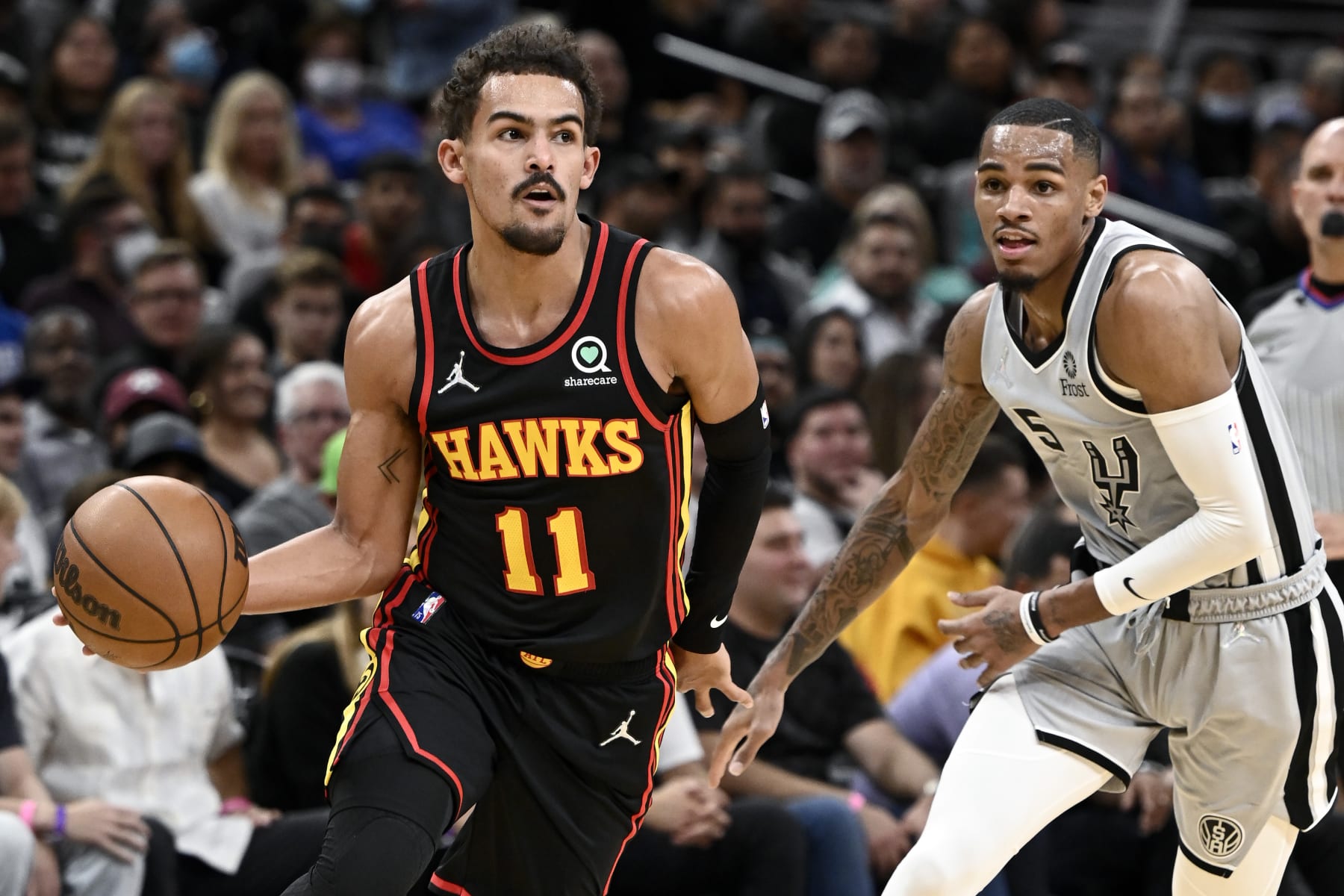 Atlanta Hawks' Trae Young (11) drives past San Antonio Spurs' Dejounte Murray during the first half of an NBA basketball game, Wednesday, Nov. 24, 2021, in San Antonio. (AP Photo/Darren Abate)
