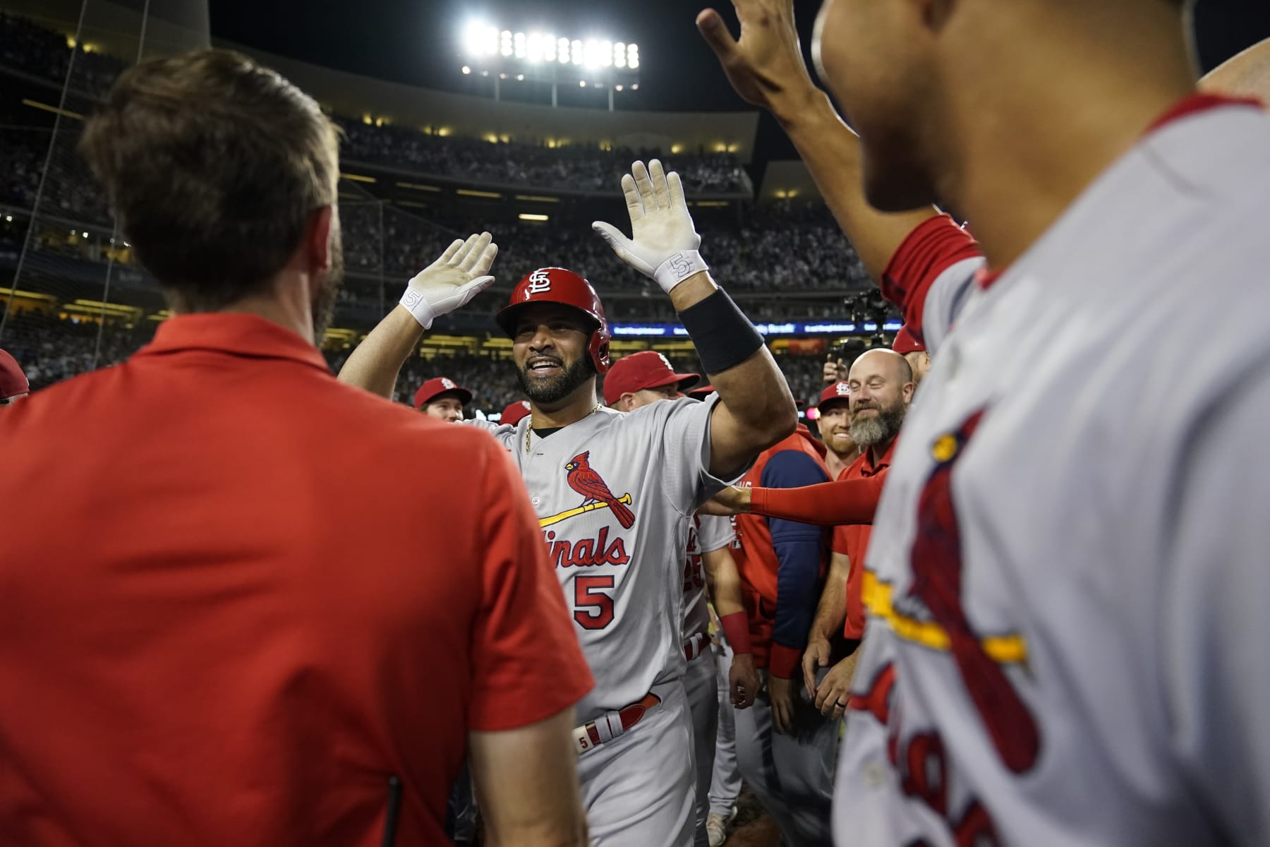 St. Louis Cardinals designated hitter Albert Pujols, center, celebrates with teammates after hitting a home run during the fourth inning of a baseball game against the Los Angeles Dodgers in Los Angeles, Friday, Sept. 23, 2022. Brendan Donovan and Tommy Edman also scored. It was Pujols' 700th career home run. (AP Photo/Ashley Landis)