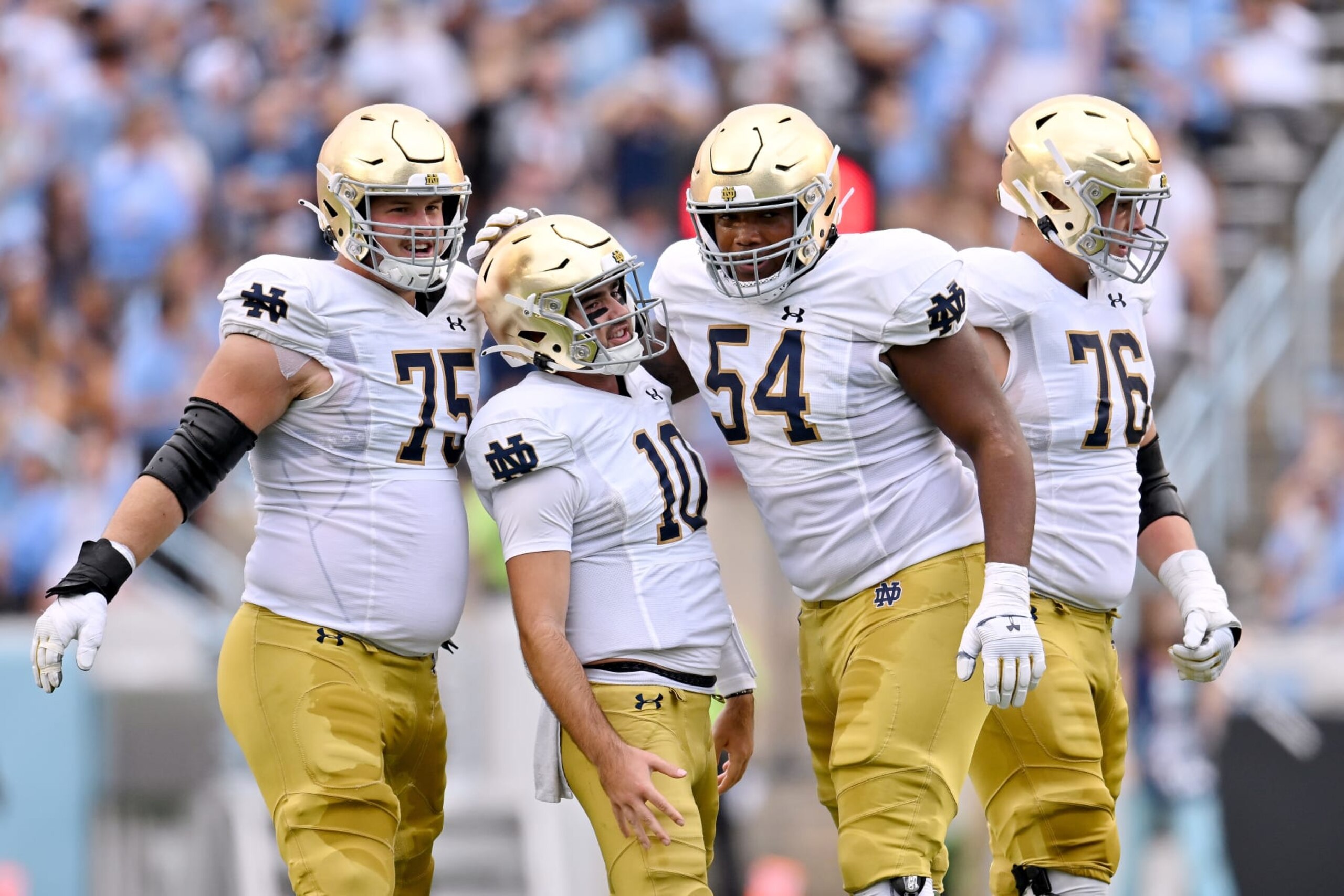CHAPEL HILL, NORTH CAROLINA - SEPTEMBER 24: Drew Pyne #10 celebrates with Josh Lugg #75 and Blake Fisher #54 of the Notre Dame Fighting Irish after throwing for a touchdown against the North Carolina Tar Heels during the first half of their game at Kenan Memorial Stadium on September 24, 2022 in Chapel Hill, North Carolina. (Photo by Grant Halverson/Getty Images)