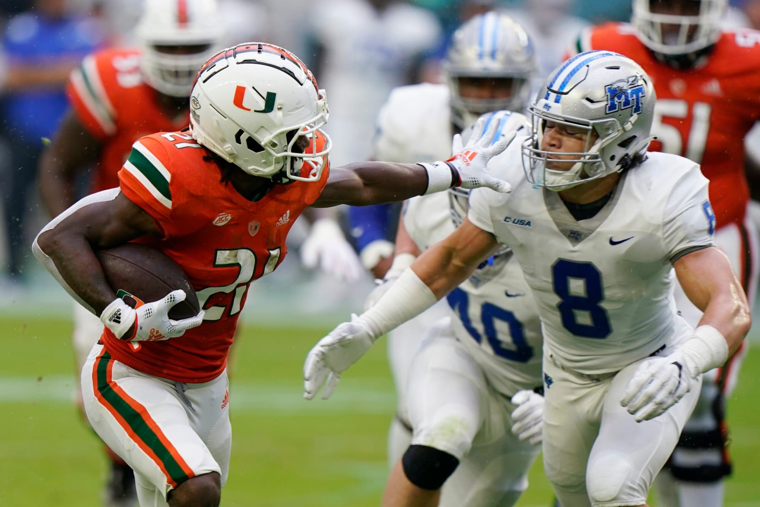 Miami running back Henry Parrish Jr. (21) runs for yardage against Middle Tennessee linebacker Devyn Curtis (8) during the first half of an NCAA college football game, Saturday, Sept. 24, 2022, in Miami Gardens, Fla. (AP Photo/Wilfredo Lee)